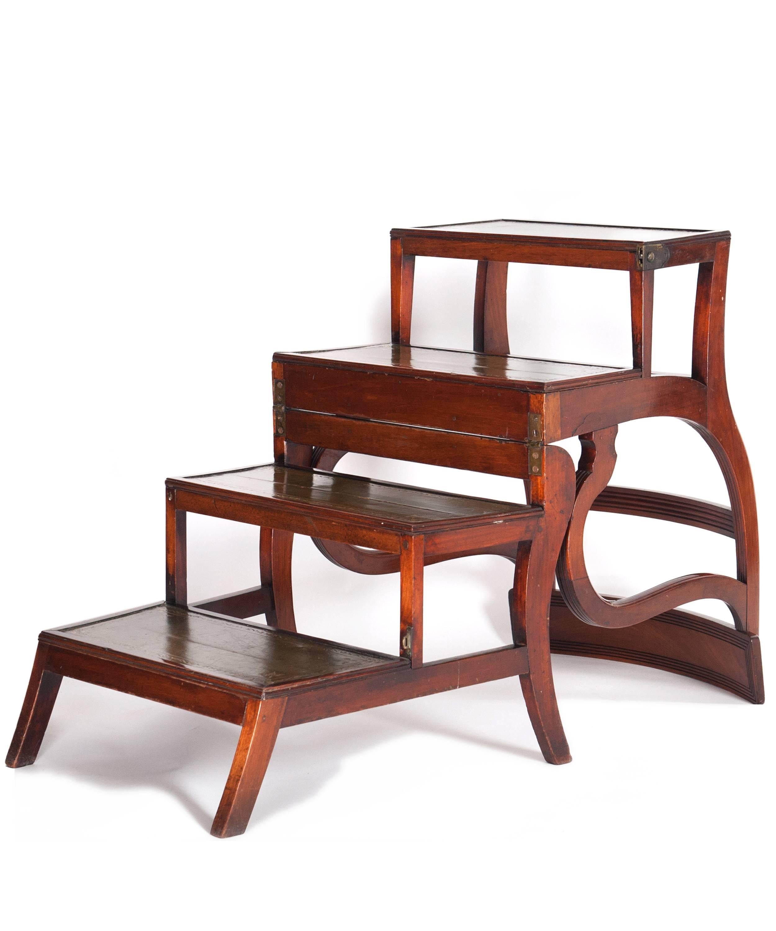 A good metamorphic English library chair or steps, after patented design by Morgan & Sanders.
With four stair steps, three inlaid with green leather
Canned reed seat
Scrolled arms
Molded front
Raised on sabre legs
When folded into a chair,