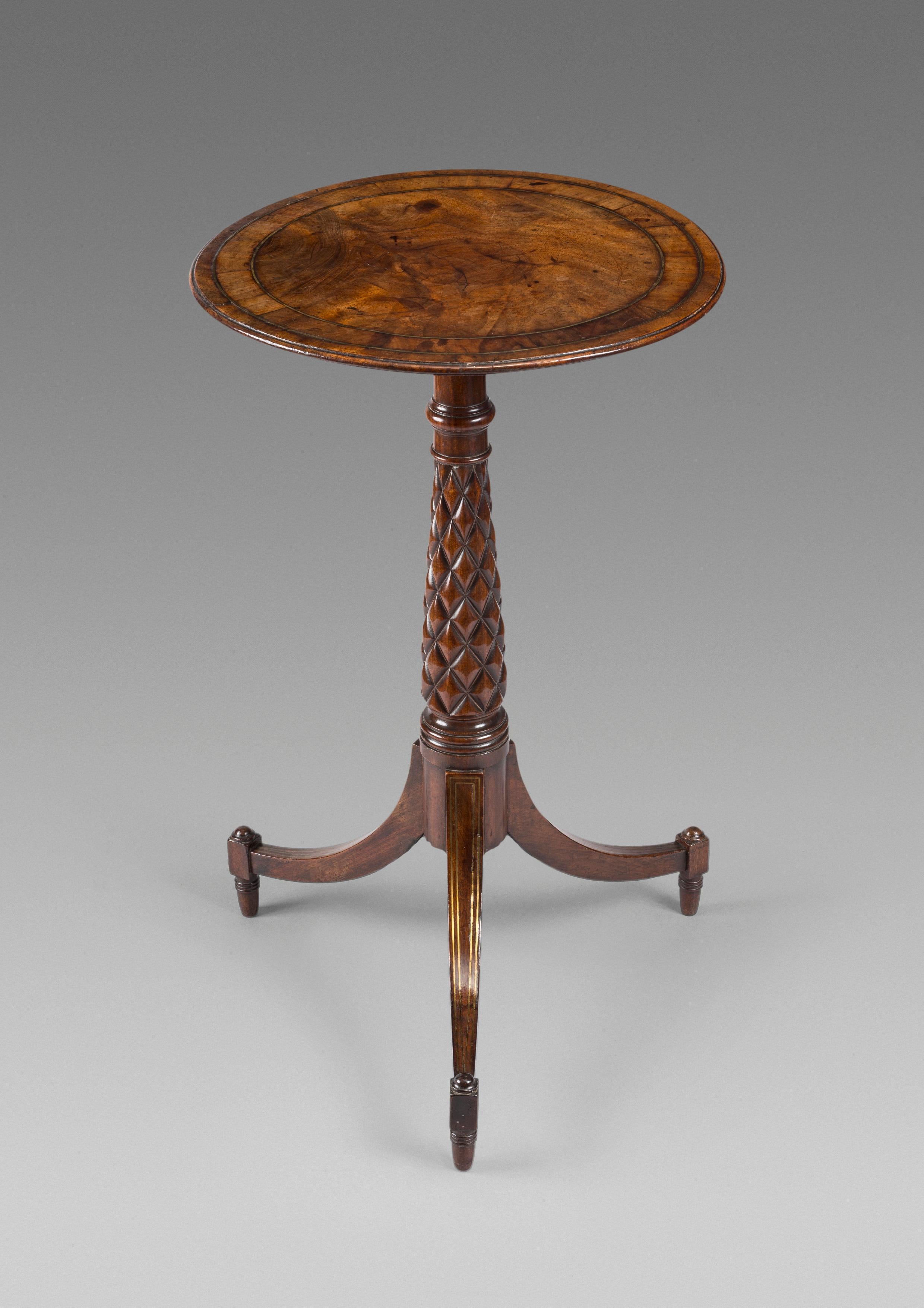 A very attractive early 19th century Regency period circular tripod table in beautifully figured mahogany. The circular top which is nicely patinated and with brass banding, is supported on a carved stem. The table is elegantly raised on three