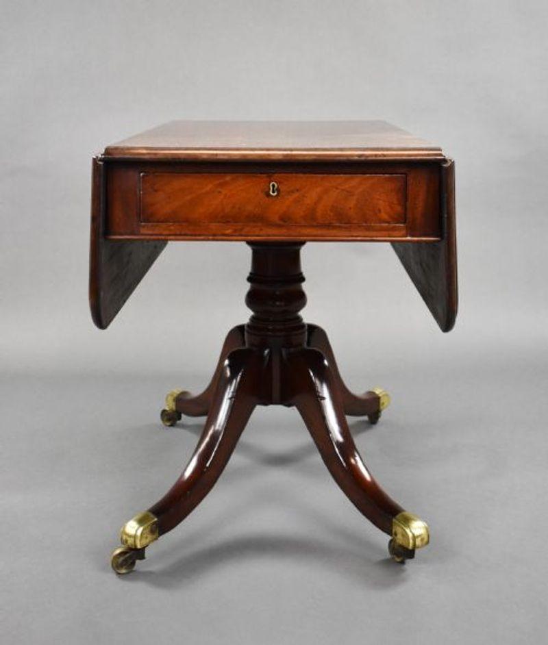 For sale is a good quality Regency mahogany pembroke table, having two drop leaves and a drawer to the front, with a faux drawer on the opposing side, above a turned stem raised on splayed legs terminating with brass castors. The table is in very