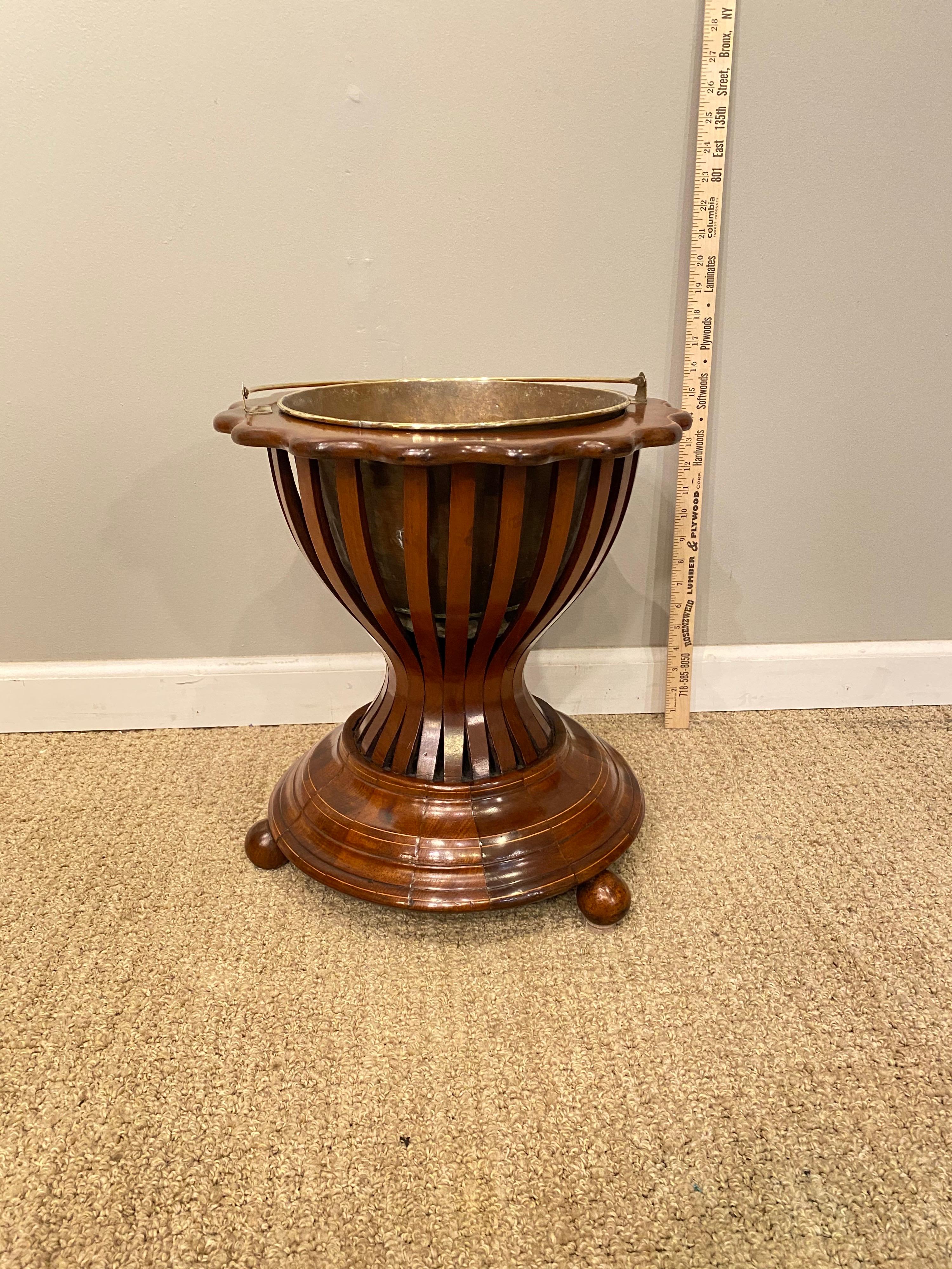 Mahogany planter with brass liner and handle.