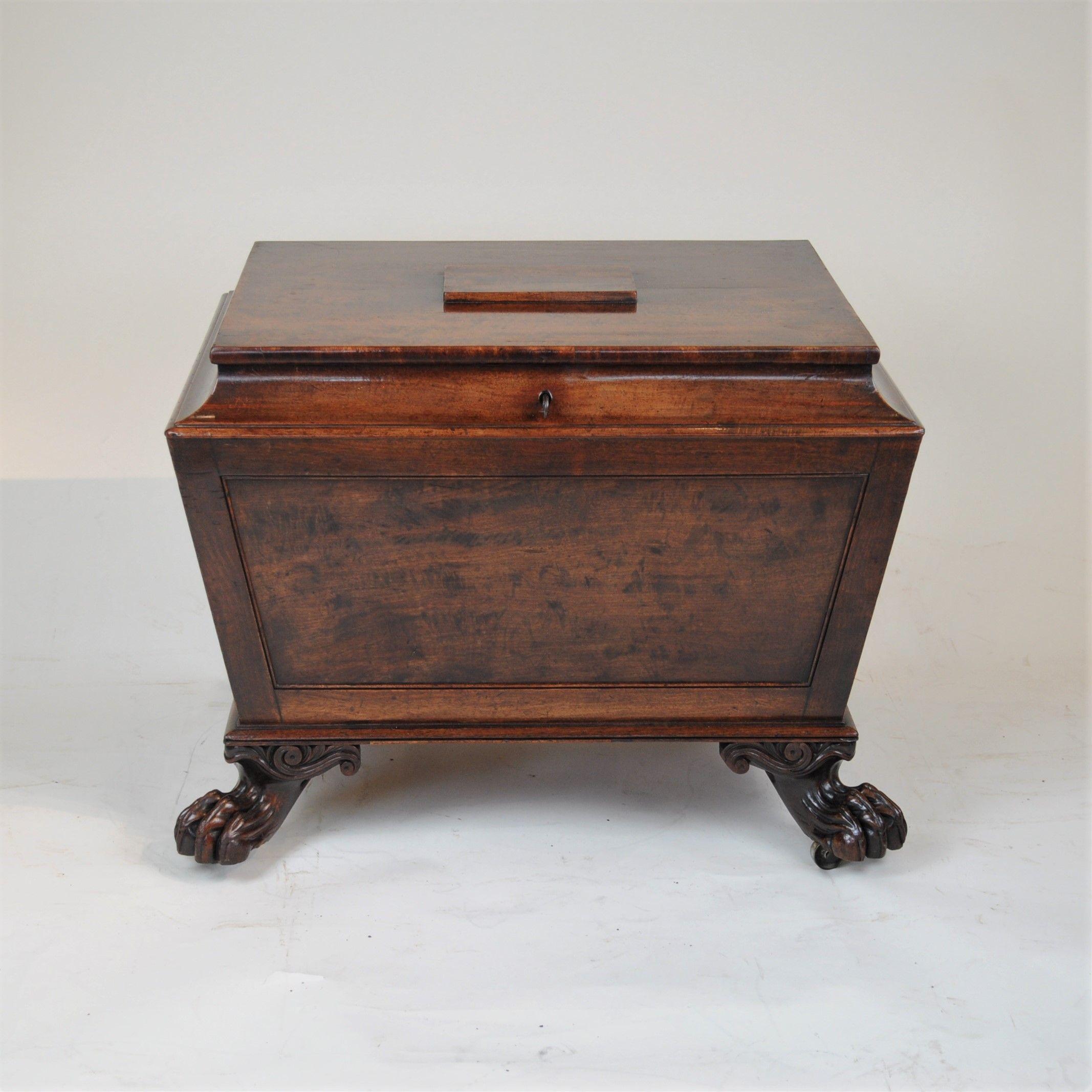 A fine quality Regency period, figured mahogany cellarette, the flat top with slightly raised central panel, opening to reveal a later baize-lined interior. The tapered body and panelled body with original brass lions-mask handles and raised on