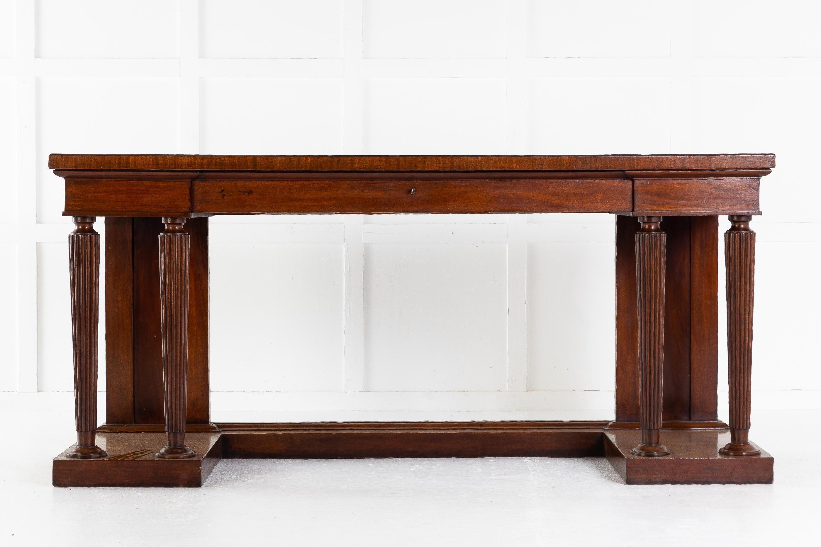 An imposing Regency mahogany neoclassical side table/serving table, in the manner of Gillows. Having a well figured rectangular top with a slender moulding and crossbanded edge, above an inverted breakfront frieze incorporating a long central drawer