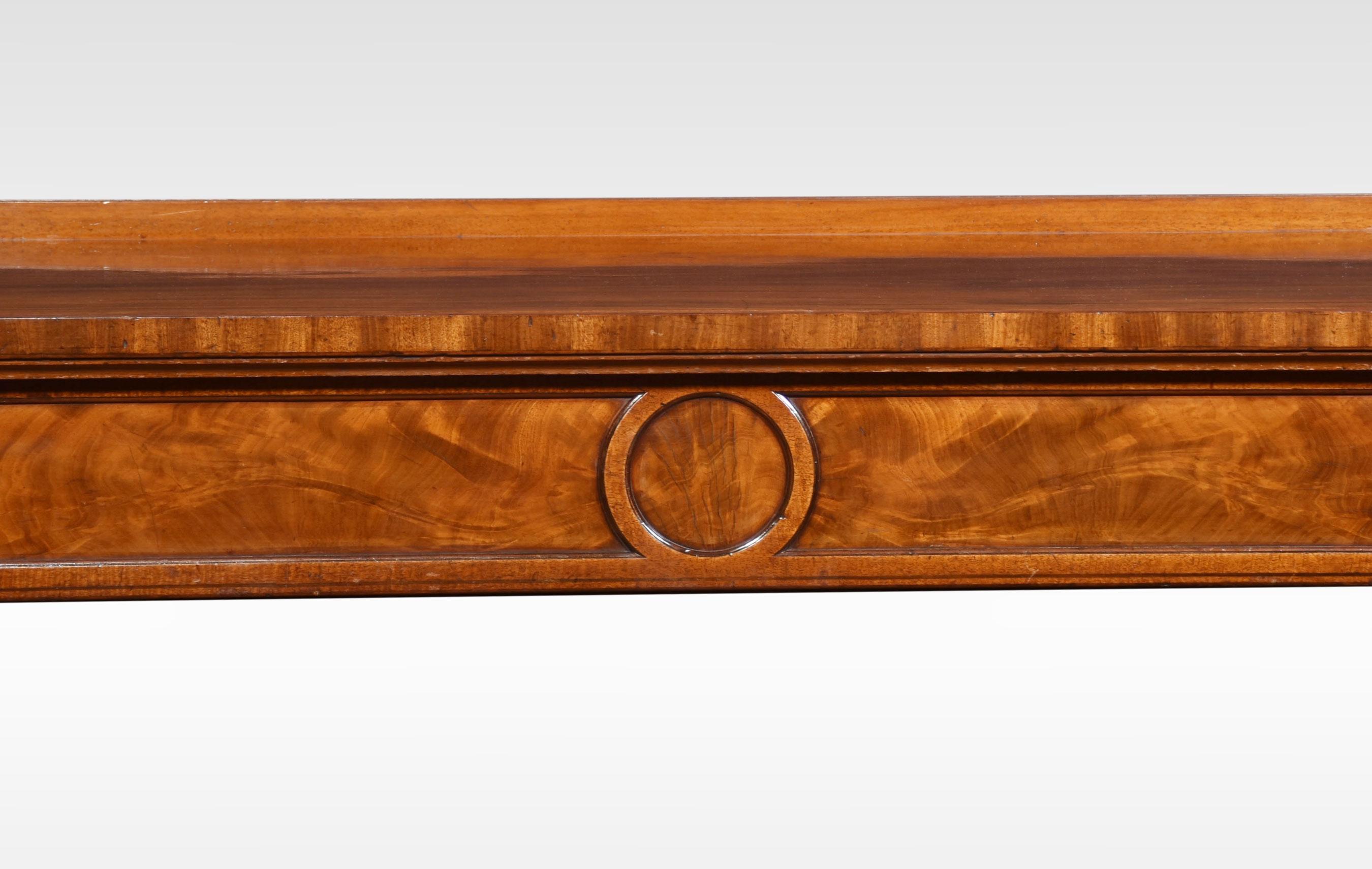 Regency mahogany console table the large rectangular top with low raised back and ebonized stringing above a carved molded frieze fitted with three drawers. All raised up on six acanthus carved square fluted supports terminating in spade