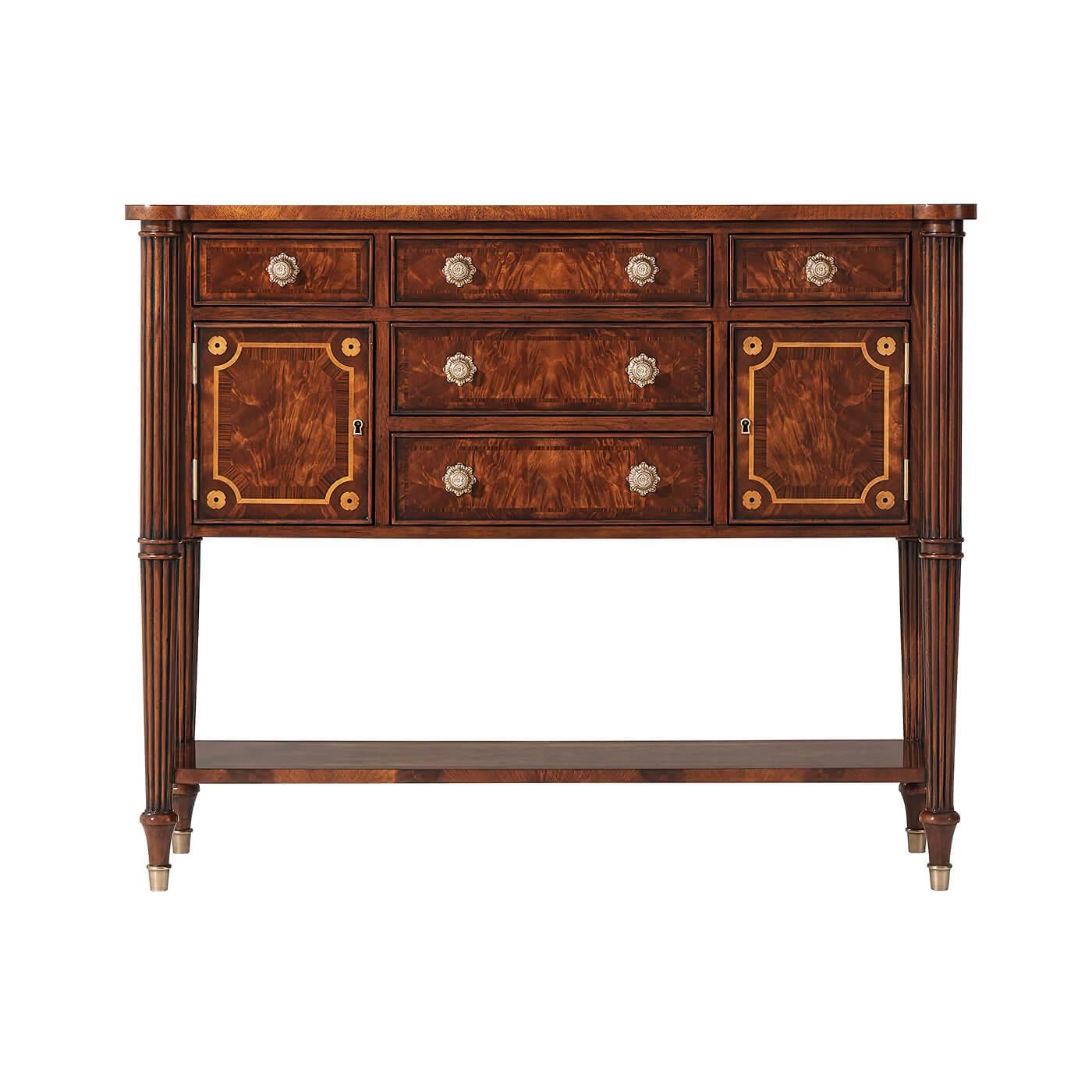 An English Regency style flame mahogany and rosewood banded sideboard, with five drawers and two cabinet doors, on turned and reeded legs joined by an under tier. 

Dimensions: 42
