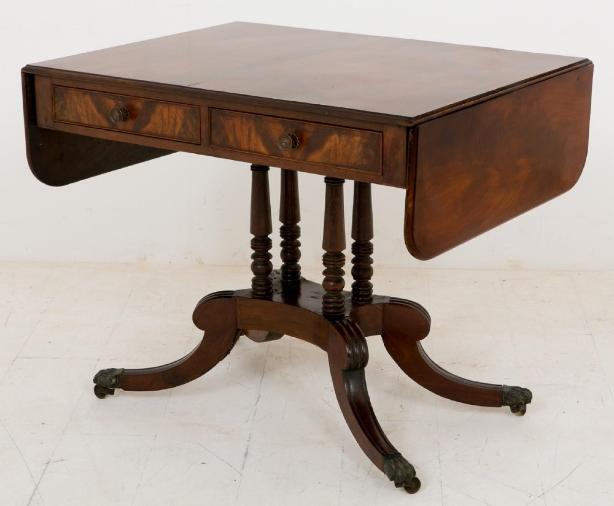 Mesa de sofá de caoba de la Regencia, sobre ruedas de latón con garras y pata redondeada.
Con 4 columnas anulares torneadas.
hacia 1800
La encimera consta de 2 cajones de trabajo y 2 cajones ficticios.