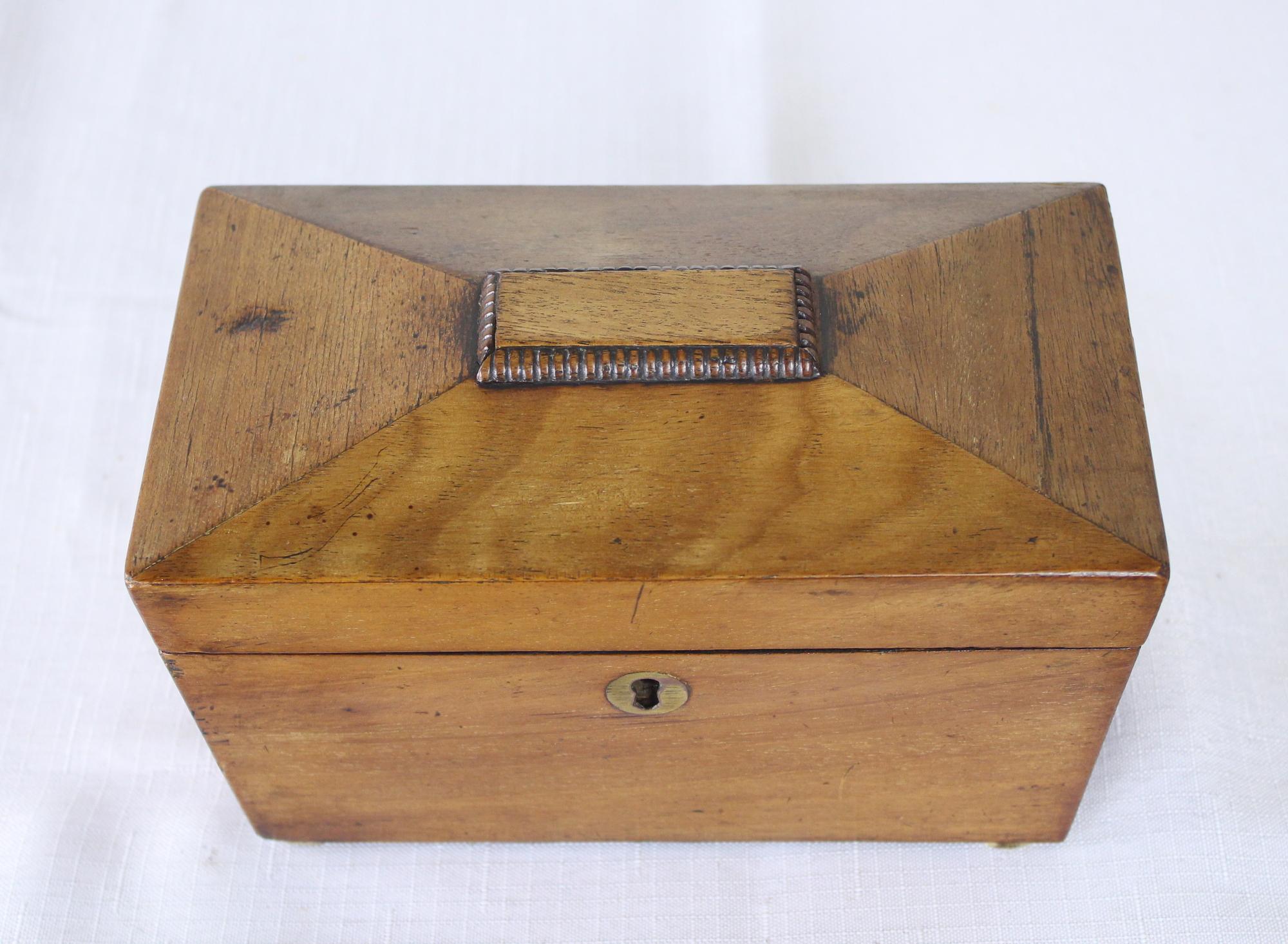 A splendid sarcophagus shaped mahogany tea caddy with charming reeded detail on top, circa 1820. The interior has its original compartment tops and the original interior paper. Good color and patina and in very nice antique condition. No key.