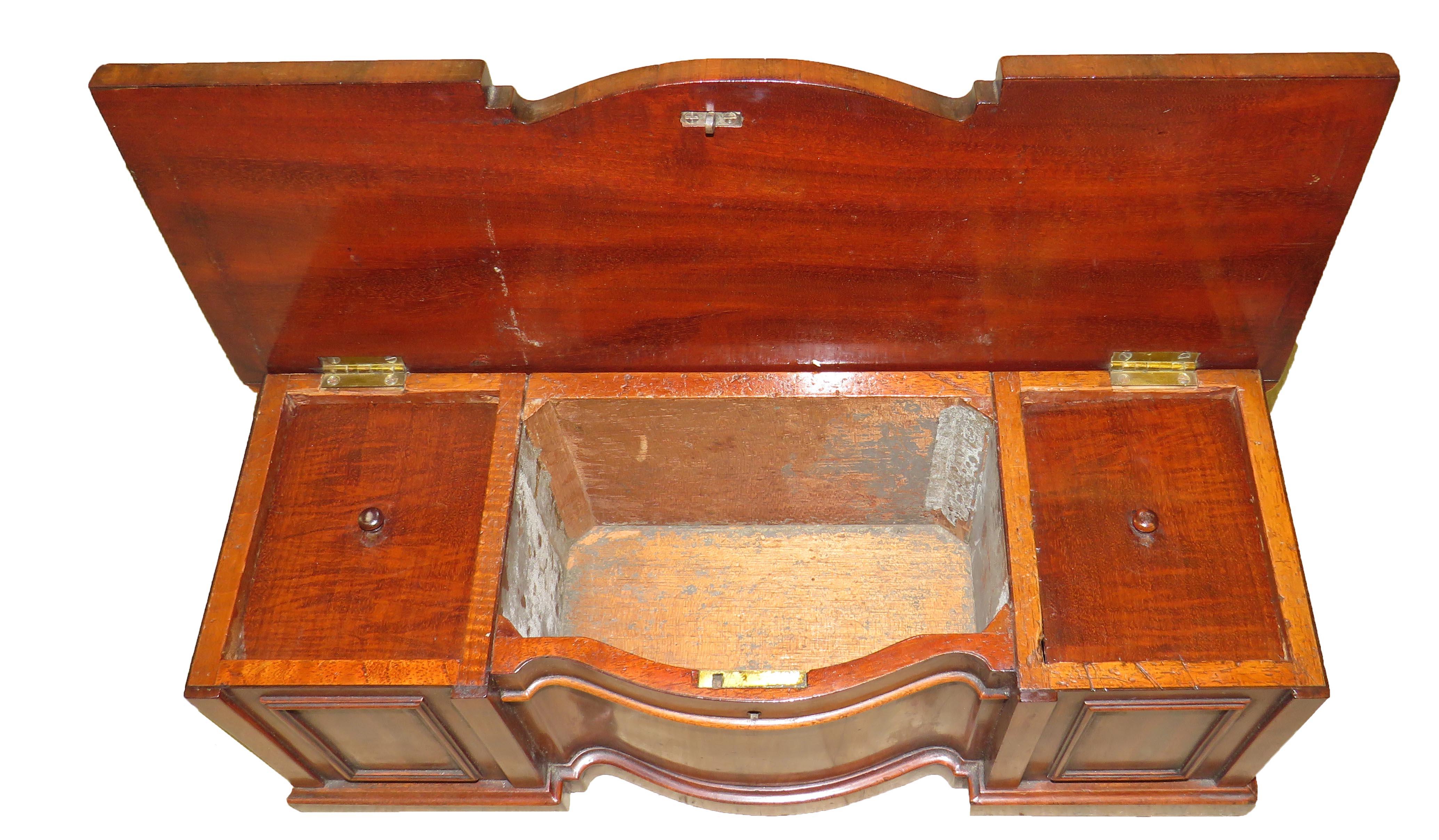 A rare and very good quality English Regency period
mahogany tea caddy in the form of a miniature serpentine
sideboard with lift up hinged lid and carved decoration

(This unusual piece is a combination of both a piece of
miniature furniture
