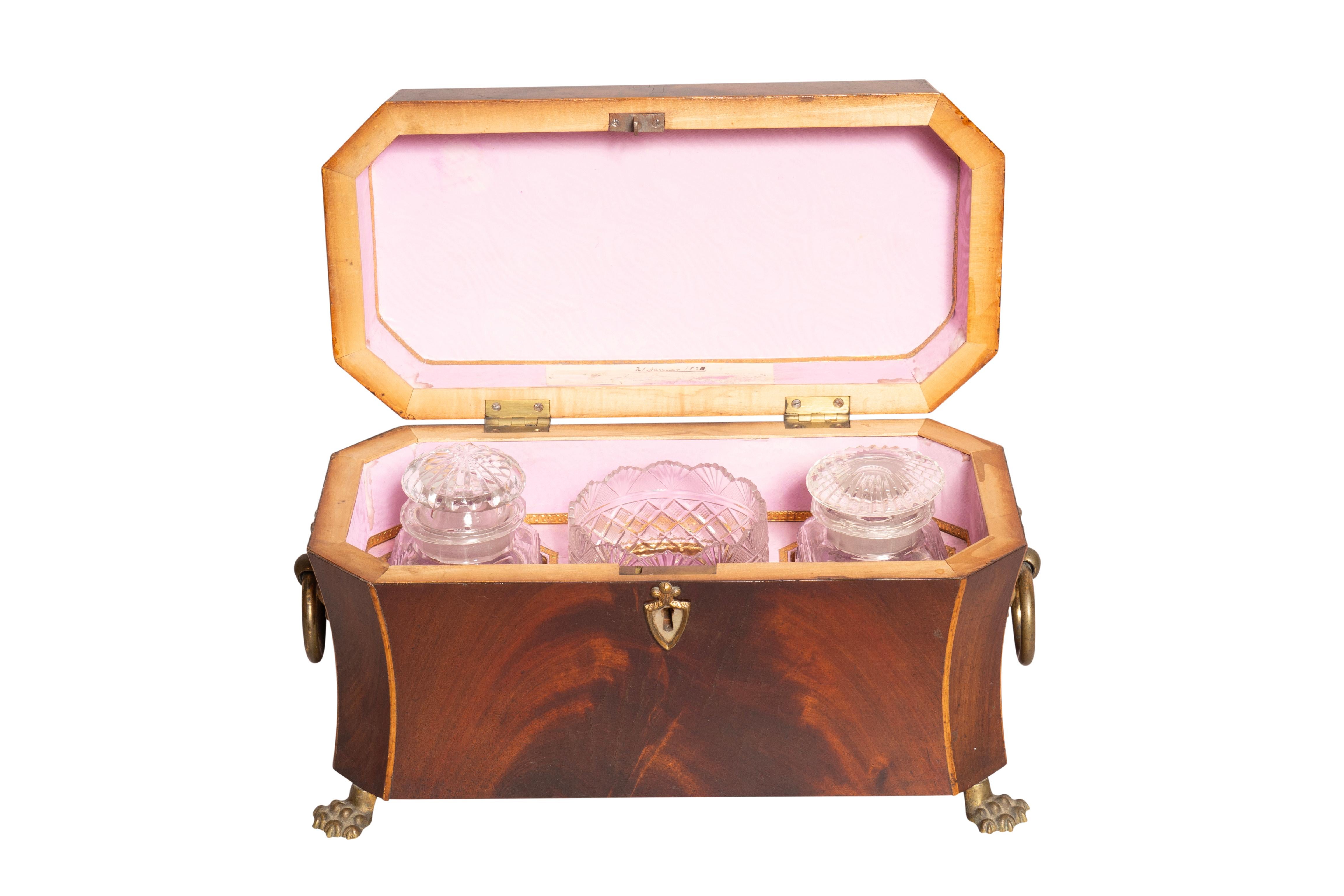 Finest quality dated January 2, 1820. Rectangular hinged top with boxwood stringing along the edge. The interior lined with pink paper and holding two cut glass tea containers and a mixing bowl. Shaped sides showing cabinet makers skill. Brass ring