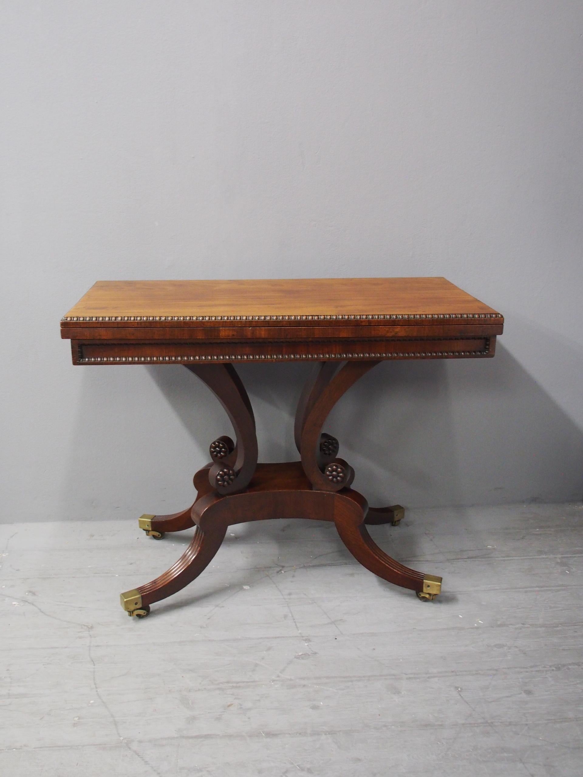 Regency mahogany tea table by William Trotter of Edinburgh. The rectangular fold over top has a beaded molded edge, and stands on the classic Trotter design, scrolling supports with carved rosettes on a quadriform base. This has hipped, reeded sabre