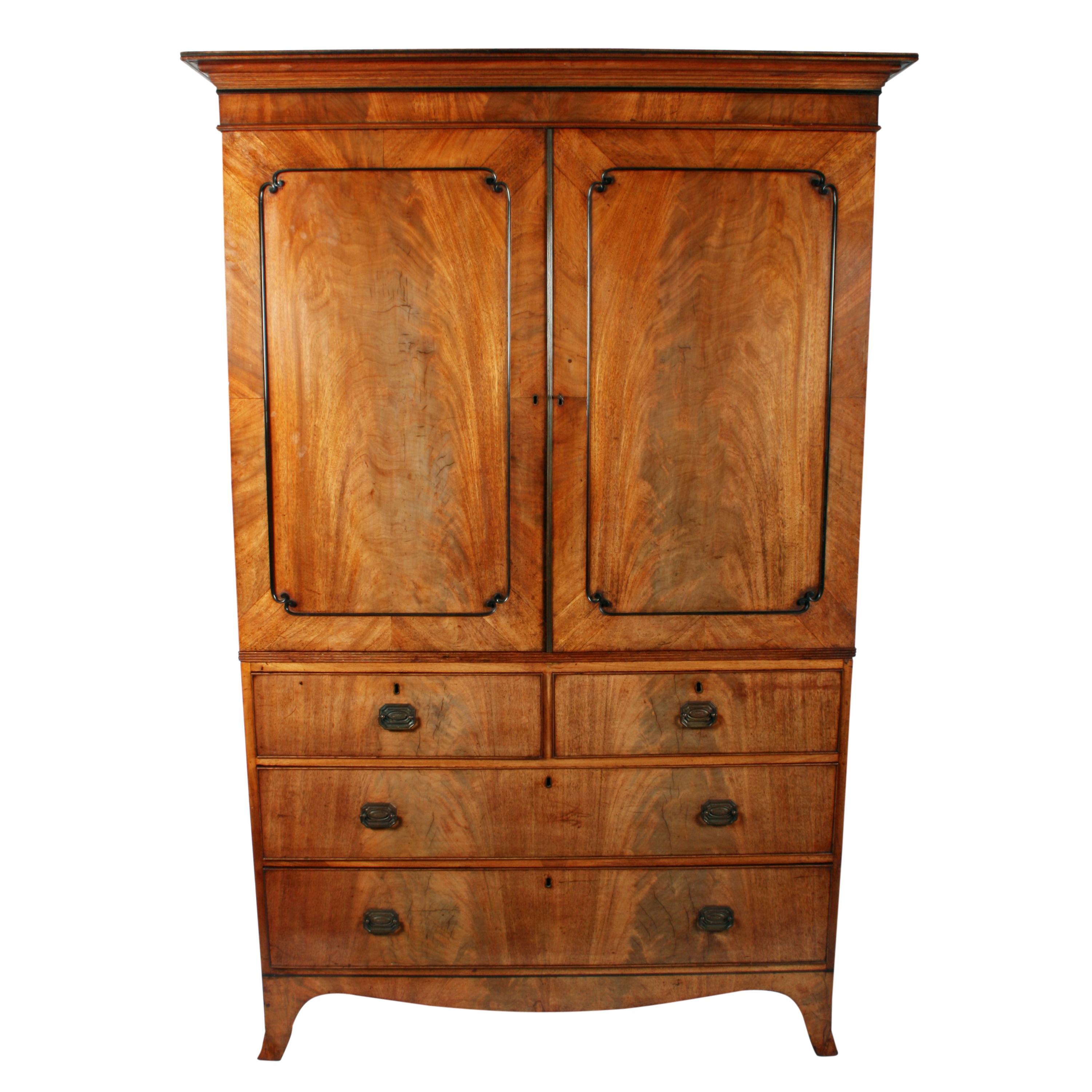 Regency mahogany tray wardrobe

An early 19th century Regency mahogany two-door tray wardrobe.

The wardrobe consists of a two-door cupboard top fitted with three oak and mahogany sliding trays and a two over two-drawer chest base.

The front