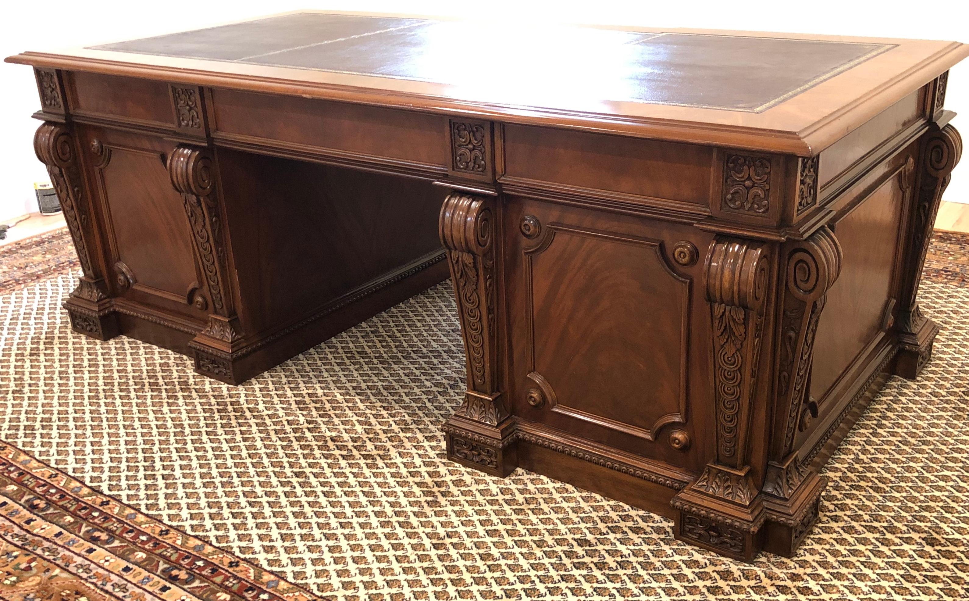 Large hand carved Regency style  mahogany twin pedestal desk with gold tooled burgundy leather top. Fine quality mahogany executive size double pedestal desk. Burgundy gold tooled leather top in three panels.