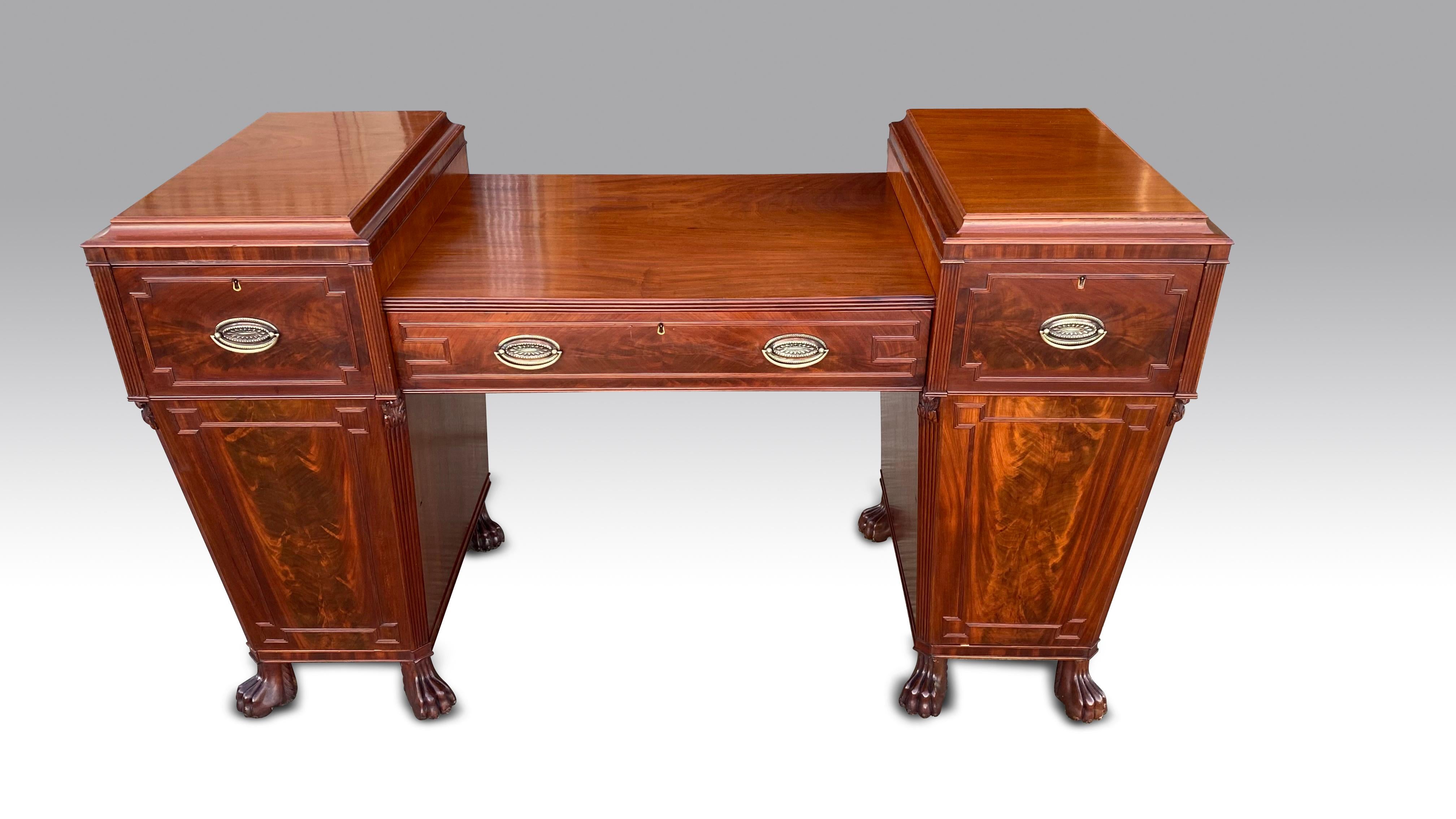 A good Regency period mahogany twin pedestal sideboard of Grecian influence.
The twin pedestals tapering downwards supported on carved lion paw feet.
The pedestals with beaded canted corners & carved capitals.
Both the doors & drawers with