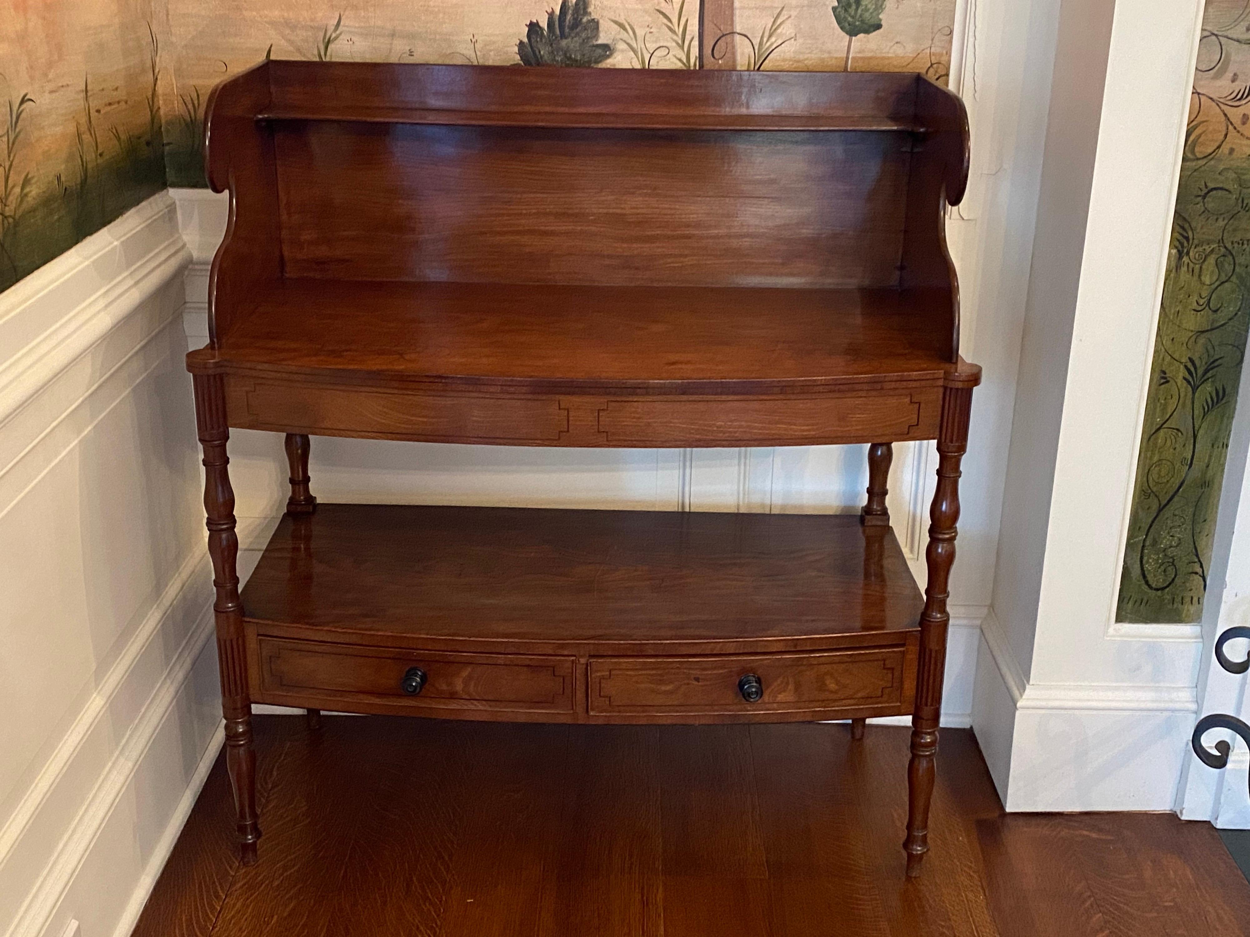 Regency mahogany wash stand, circa 1810
The bow-fronted top flanked by tall shaped superstructure above a conforming frieze raised on baluster-turned tapering legs joined by a platform stretcher fitted with a pair of short drawers.
Measures: