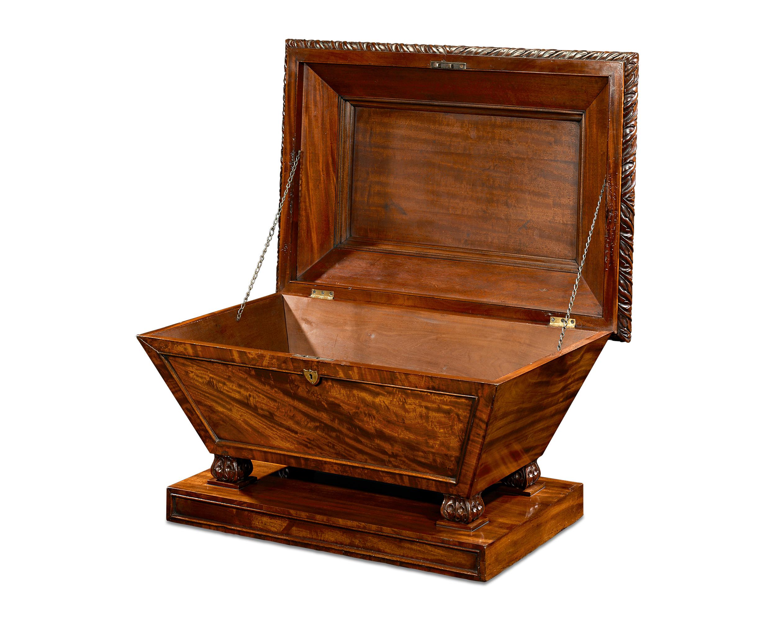 An exceptional and rare English wine cellarette is an exemplary specimen of Regency furniture. The cellarette is formed in a streamlined sarcophagus shape from beautifully grained mahogany. Neoclassical gadroon and acanthus carvings echo the