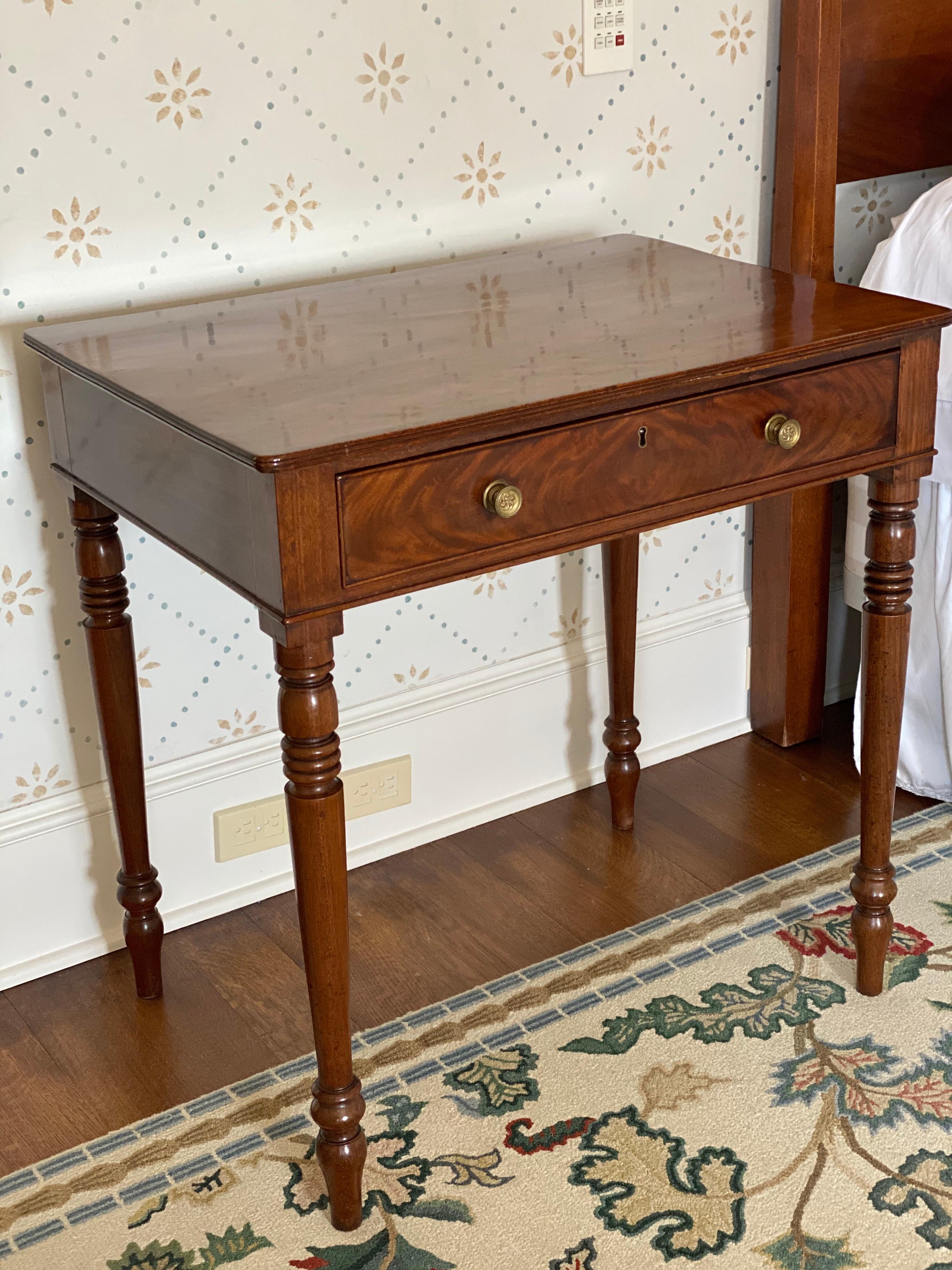 Regency mahogany writing table, circa 1810
With a fitted frieze and simulated drawer to the reverse; raised on turned, tapering legs. Drawer has place for writing utensils. 

Measures: 30