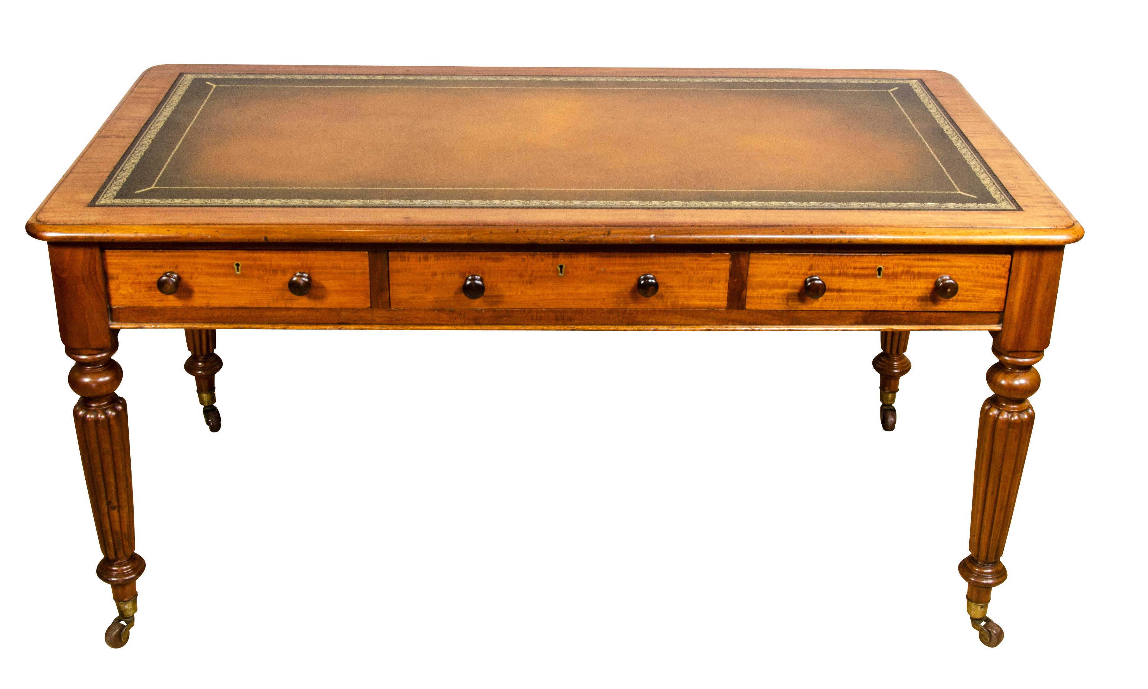 By W.Priest, London. Stamped in top of drawer. With tooled leather top with wood borders and rounded molded edge over drawers and raised on circular tapered reeded legs ending on casters.