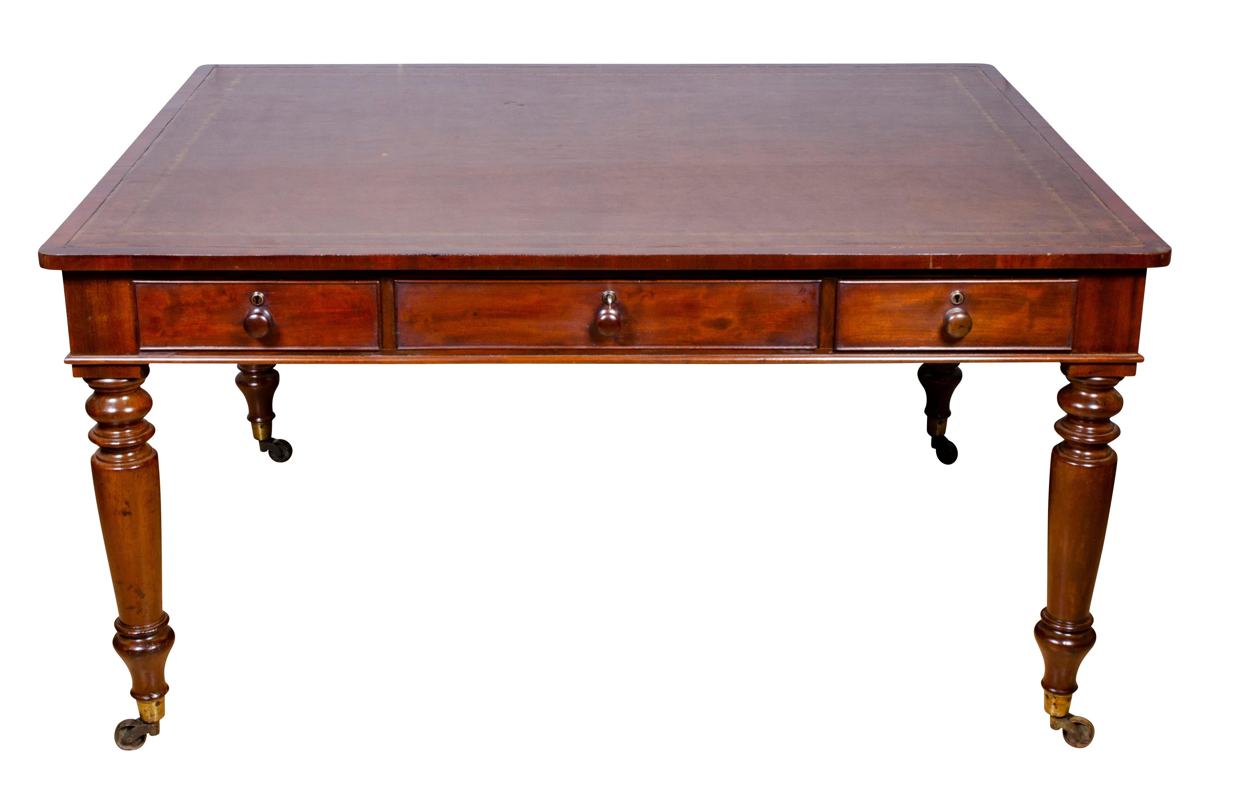 Rectangular top with inset brown leather over three drawers with wood knobs , the reverse with same configuration all raised on circular tapered legs and casters.