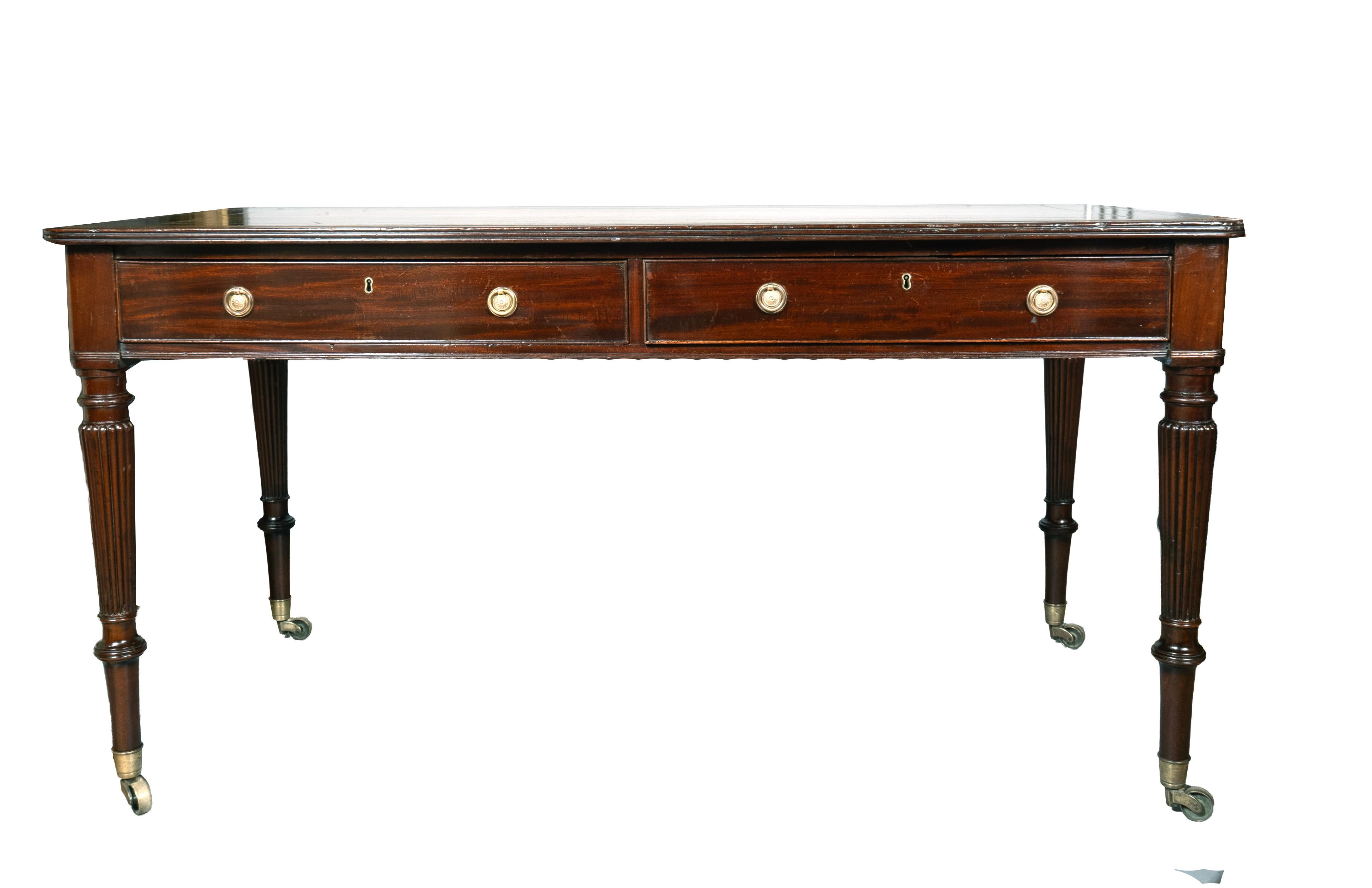 24.5 floor to underside of apron. Rectangular dark green leather with a banded and reeded edge over two drawers with brass ring handles, circular tapered reeded legs with cup casters. Leather has dents and dings but presents well but not pristine.


