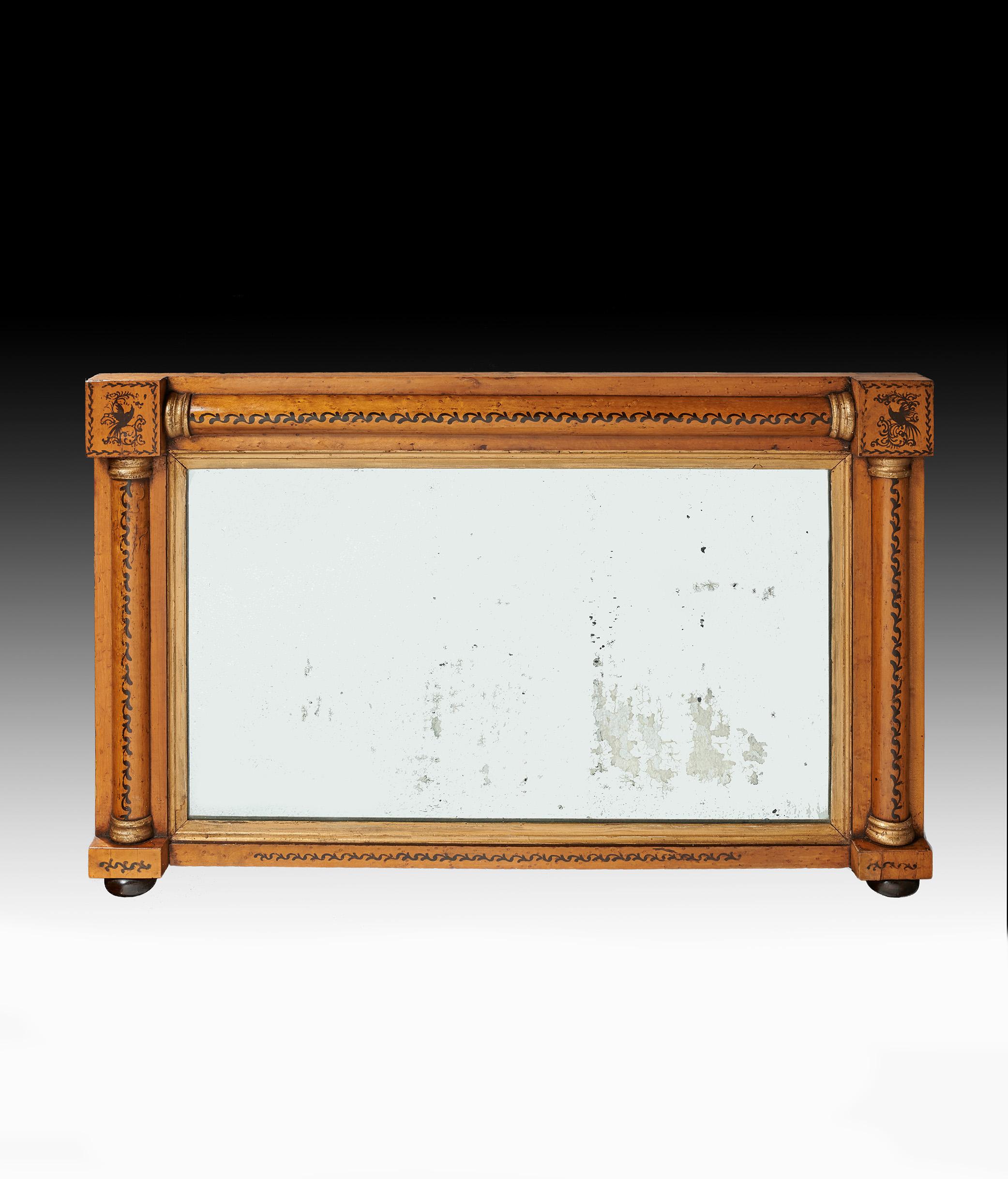 A Regency maple, gilt and penwork overmantel mirror retaining the original plate.

English circa 1820

An attractive Regency overmantel mirror within a bird's-eye maple frame having half columns to the sides and top with gilded capitals and gilt