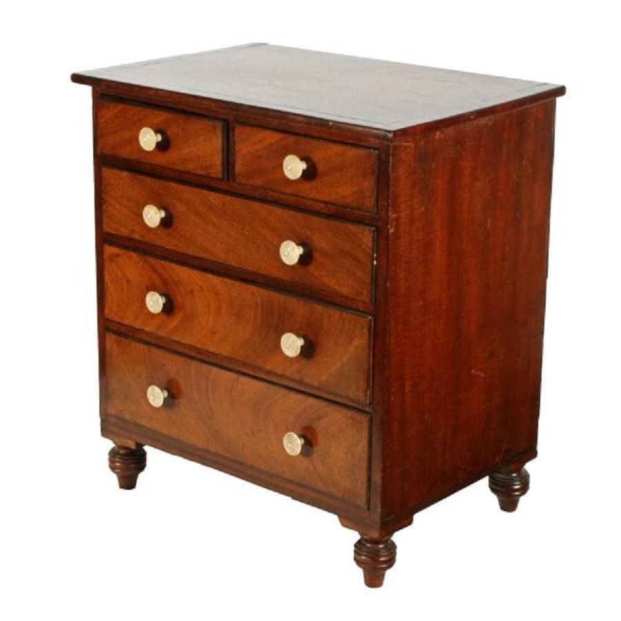 An early 19th century Regency miniature mahogany chest of drawers.

The chest is possibly an apprentice piece and has a figured mahogany top with line inlay and five drawers with matching inlay to the edges.

The drawers are mahogany and pine