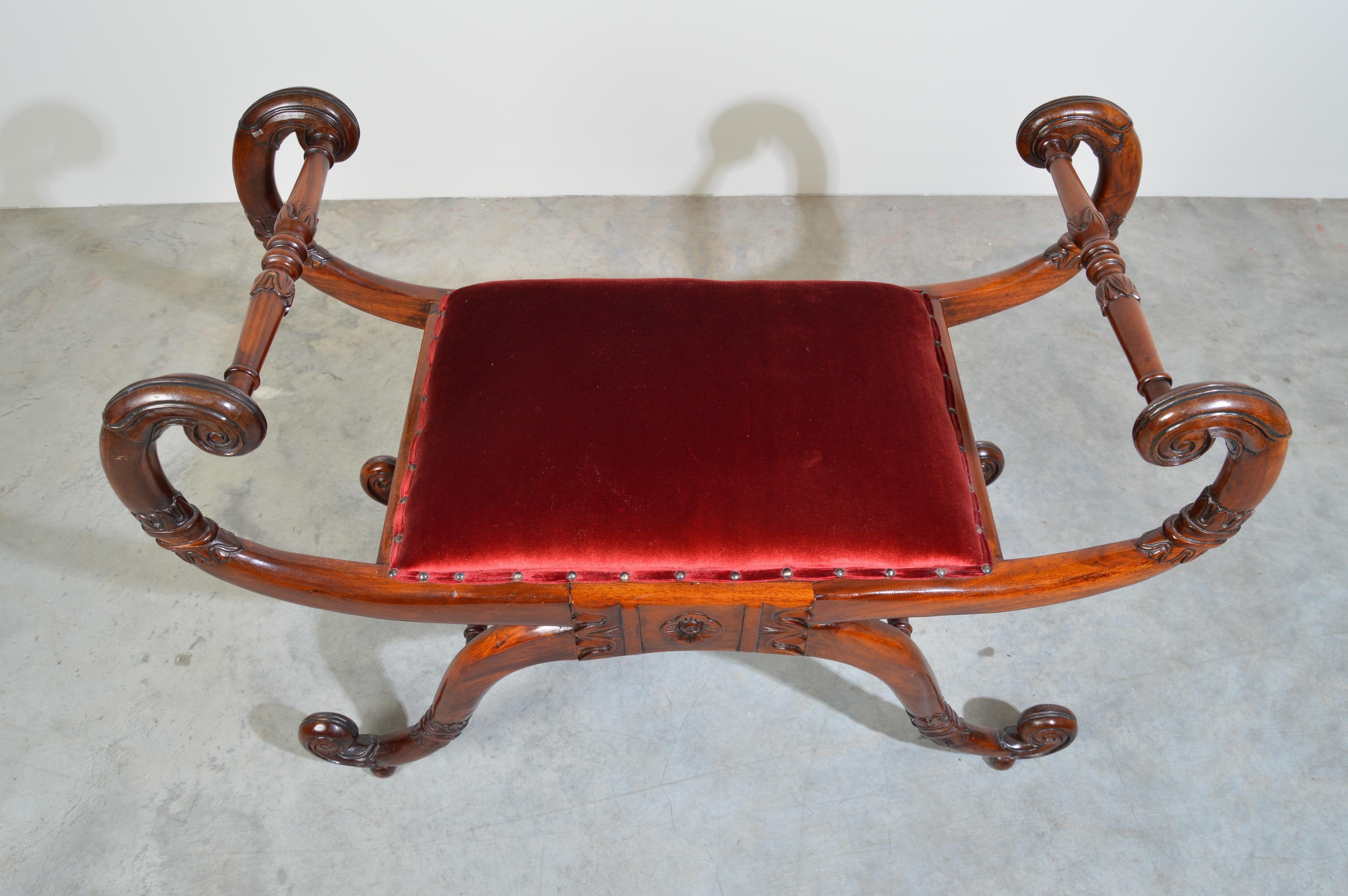 Neoclassical style bench 
Carved mahogany frame with velvet overstuffed seat cushion having flanking scroll armrests, detailed carved accenting throughout, supported on four scrolled legs each with turned
H-stretcher support. 
Absolutely stunning
