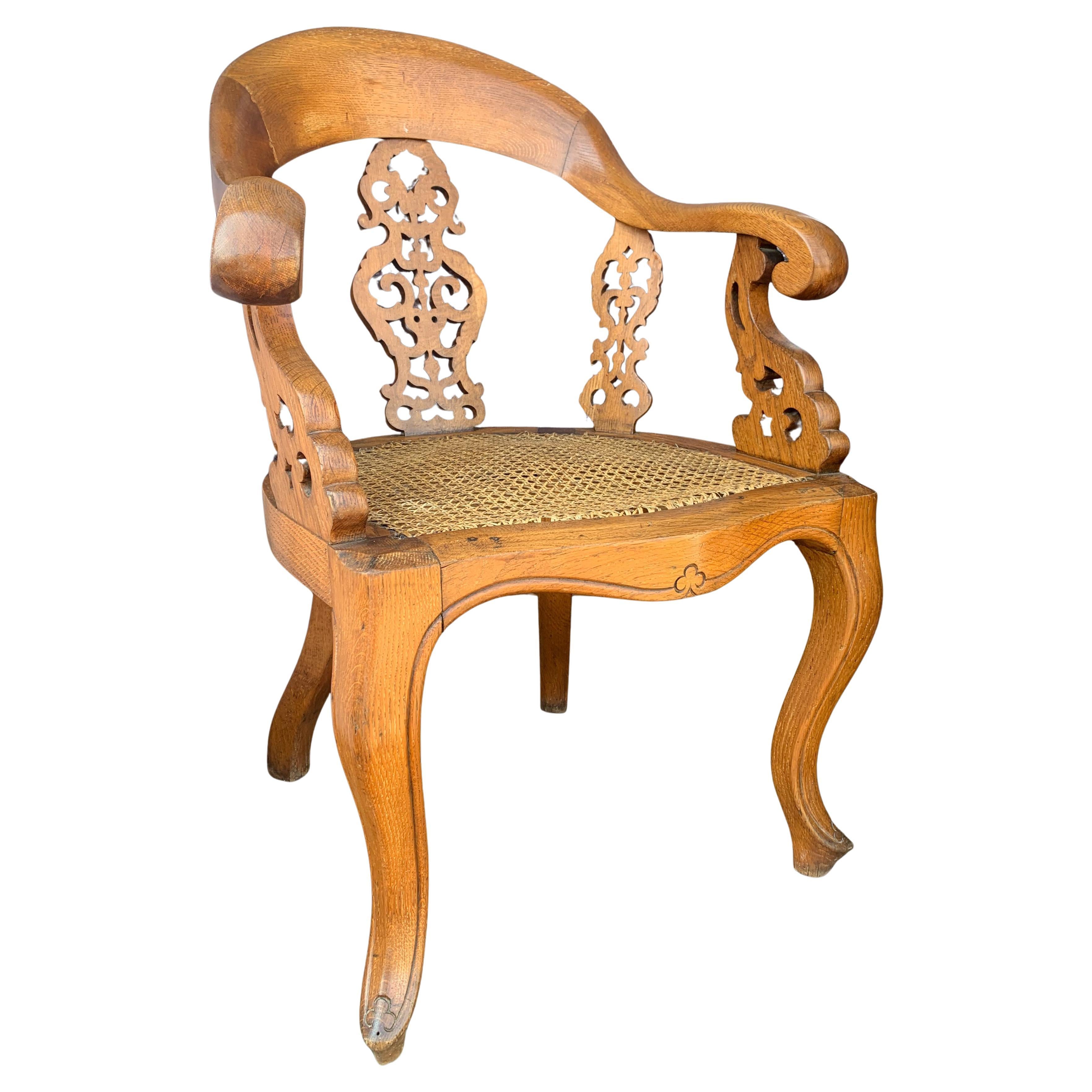 Chaise de bibliothèque en chêne de style Régence à l'arrière et aux côtés décoratifs percés, munie d'un siège canné 

Provenance de 