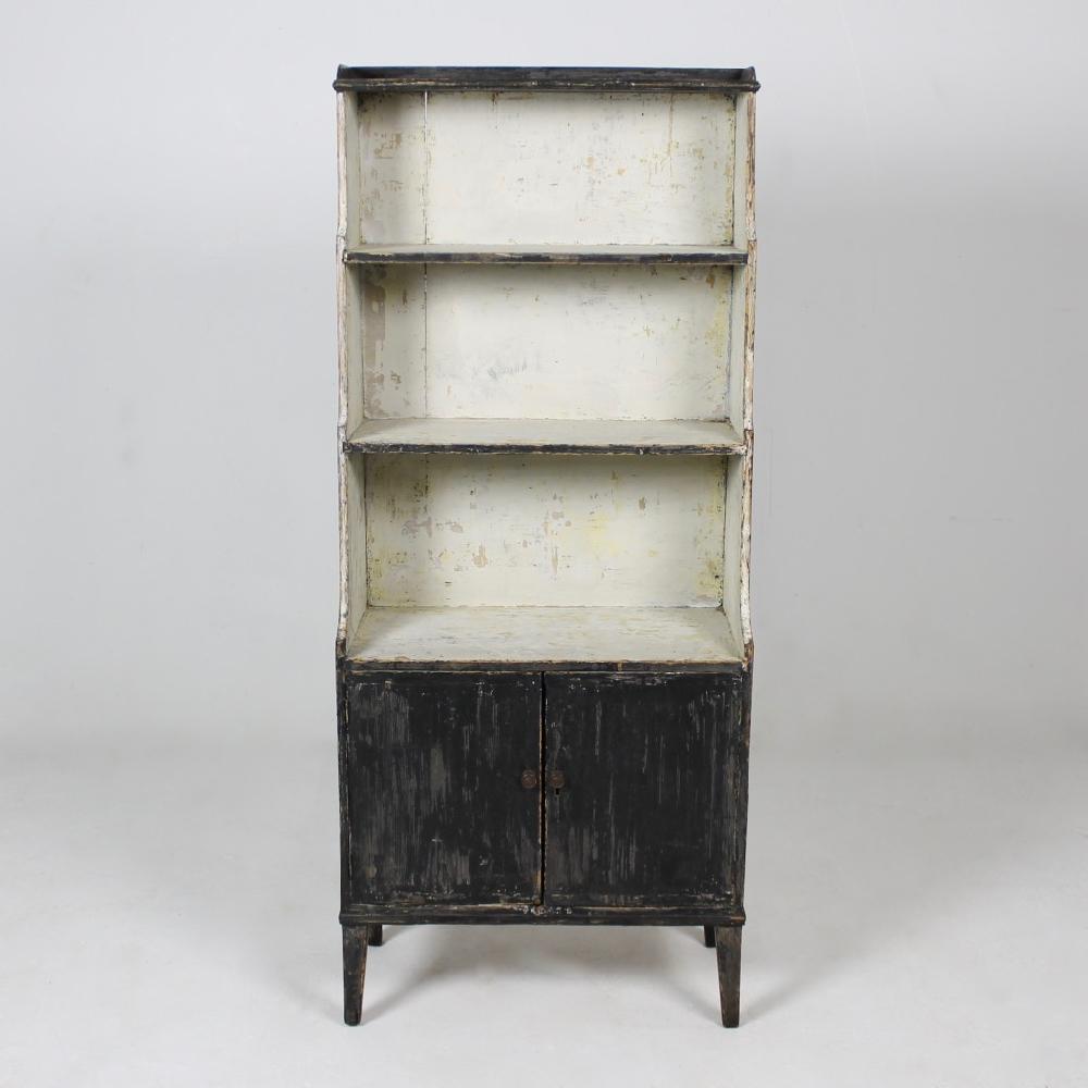 A beautifully decorative, Regency period, waterfall bookcase of small and elegant proportions. Dry scraped back to its original external black paint, the interior scraped creatively to reveal layers of ancient paint, the whole in very good