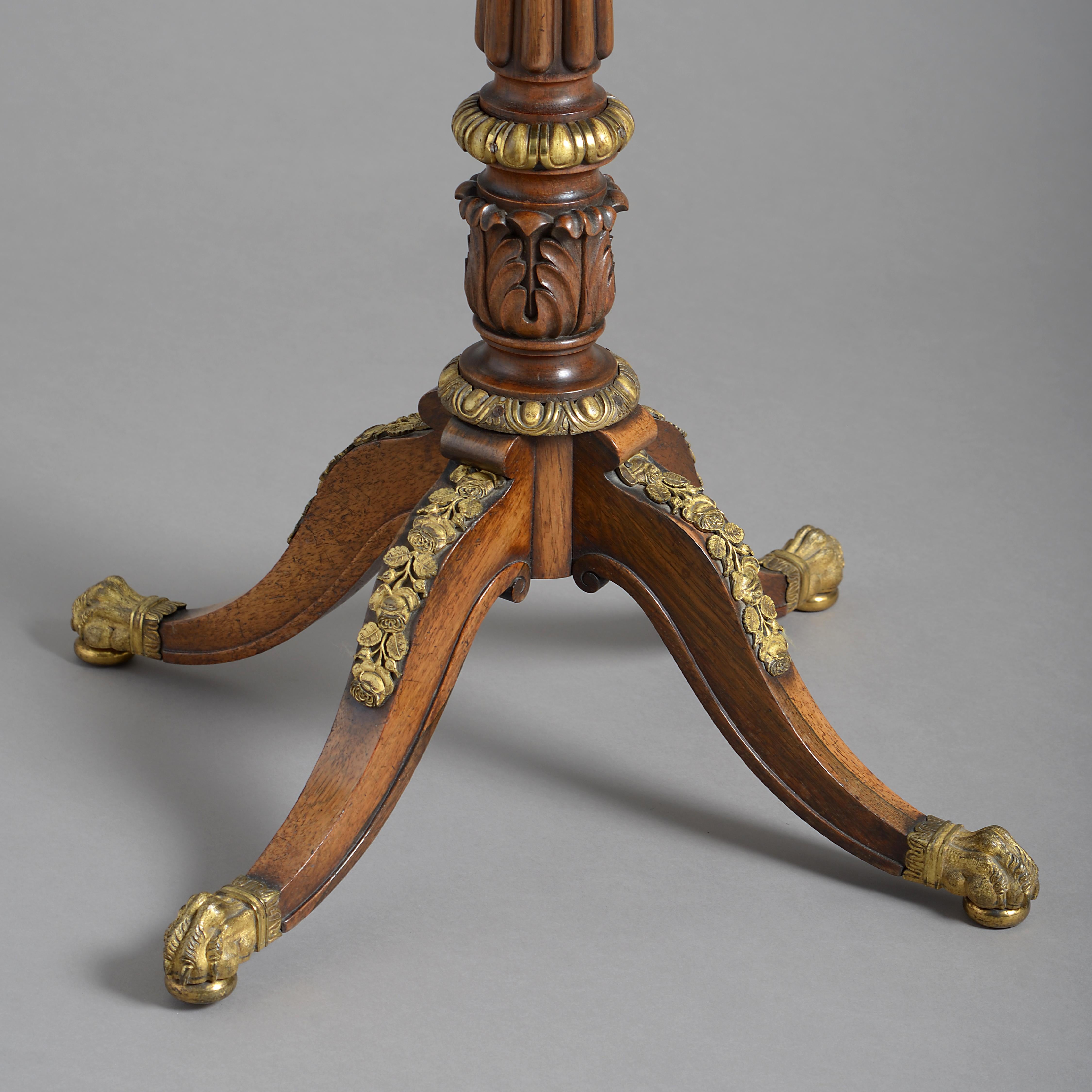 A fine late Regency ormolu mounted rosewood lamp table, circa 1820.

The canted rectangular top with a pierced gallery on a reeded and carved column, the arched down swept legs applied with trailing roses on hairy paw feet.