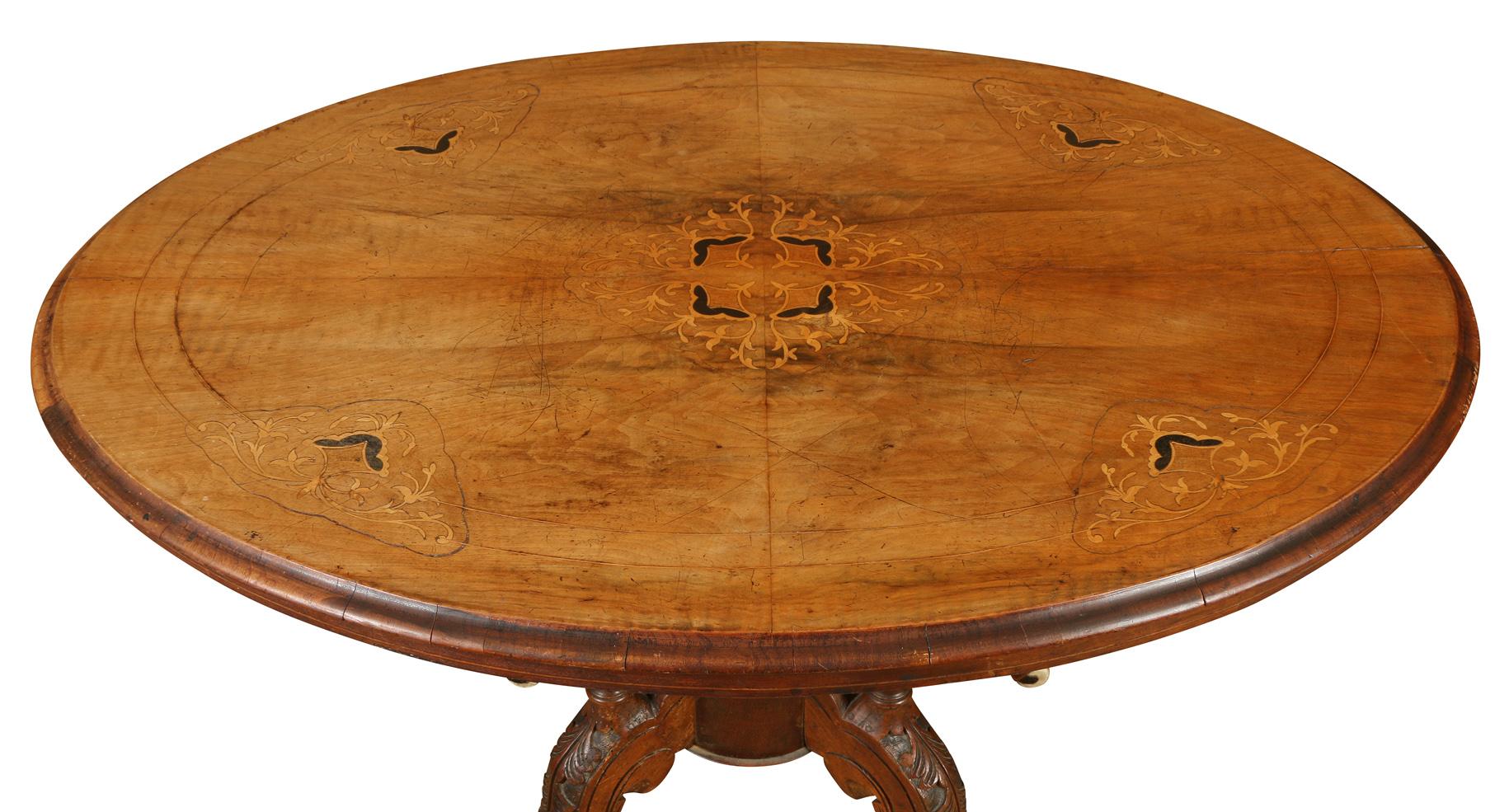 Regency style oval dining table with satinwood and ebony inlay design to top. Pedestal base has four curved legs with carving and caster feet.