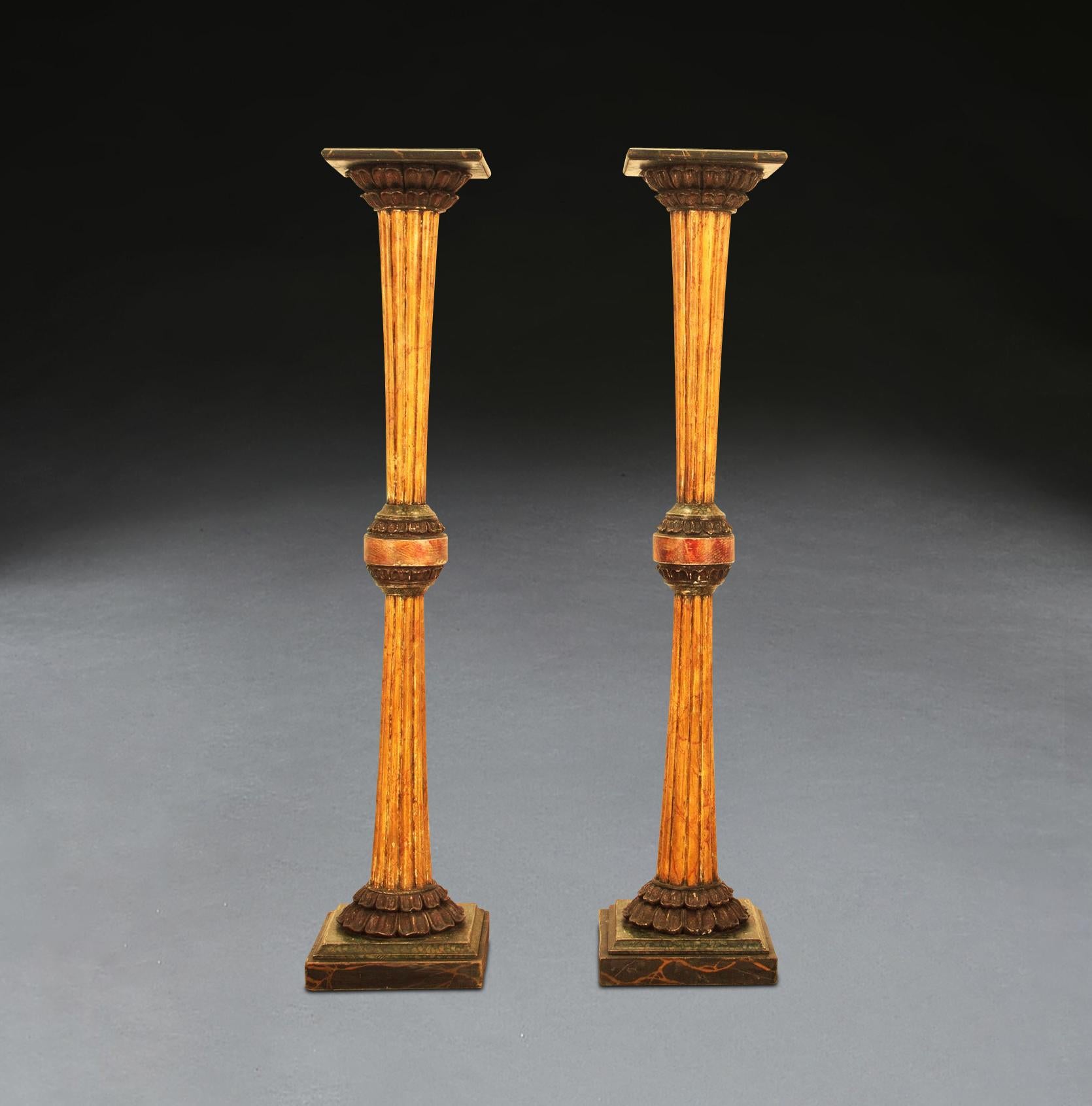 ﻿ A smart pair of Regency tall torcheres, in the Brighton Pavilion manner. Colourfully executed in simulated marble decoration. The square square top with moulded edge simulated in Porto, with acanthus capitals in red Porphyry, with sienna fluted