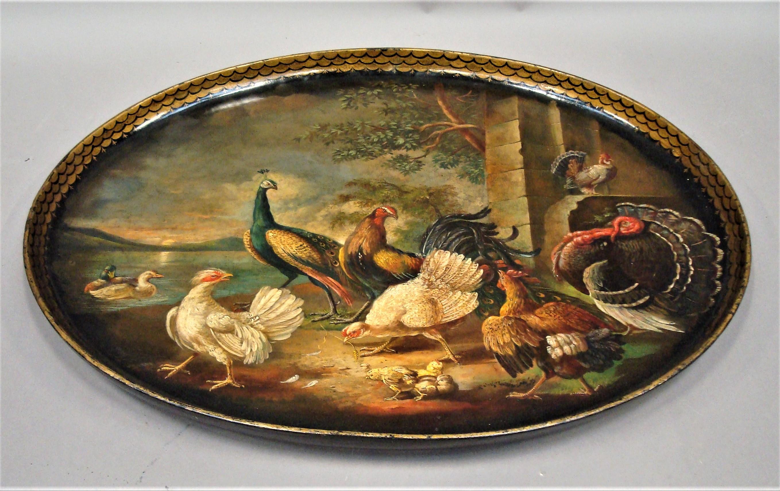 Exceptional Regency Papier Mâché tray of oval form; the raised edge decorated with a gilt fish scale design surrounding a finely painted scene of peacocks turkeys and hens with chicks in a classical landscape setting with a stone building with ducks