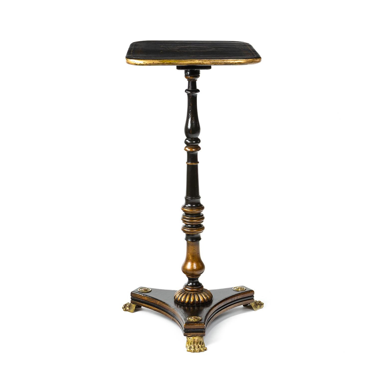 Regency parcel-gilt Japanned and ebonised pedestal occasional or wine table in the Chinoiserie style, complete with brass lion paw feet and large brass bosses to the base. The top is decorated and painted in gold in the typical style of the Regency