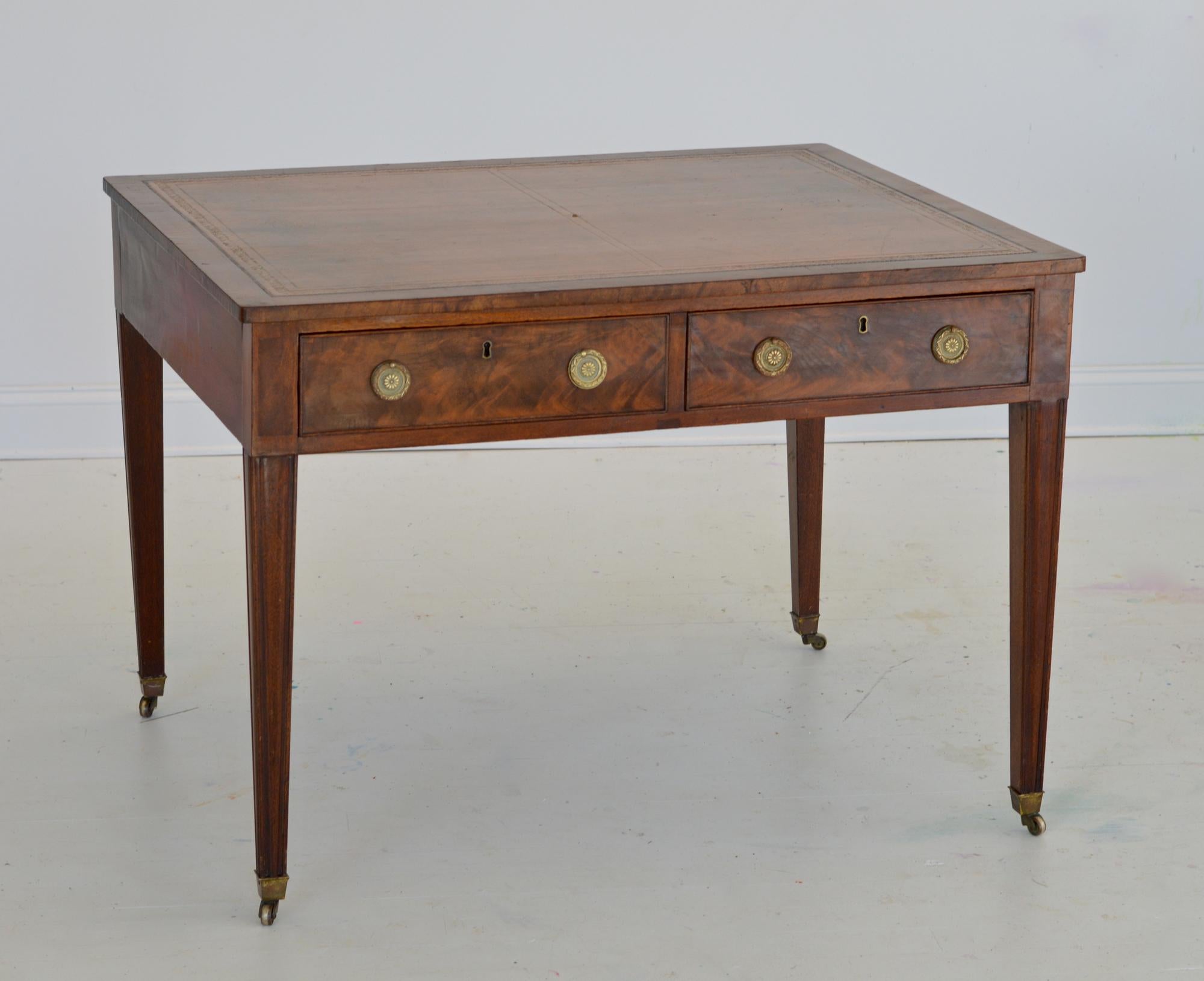 A stunning late 19th century Regency partners desk having an ample rectangular top adorned with gorgeous liver colored tooled leather. The surface is supple and rich. Each side of the writing table supplies the user with two useful and deep drawers.