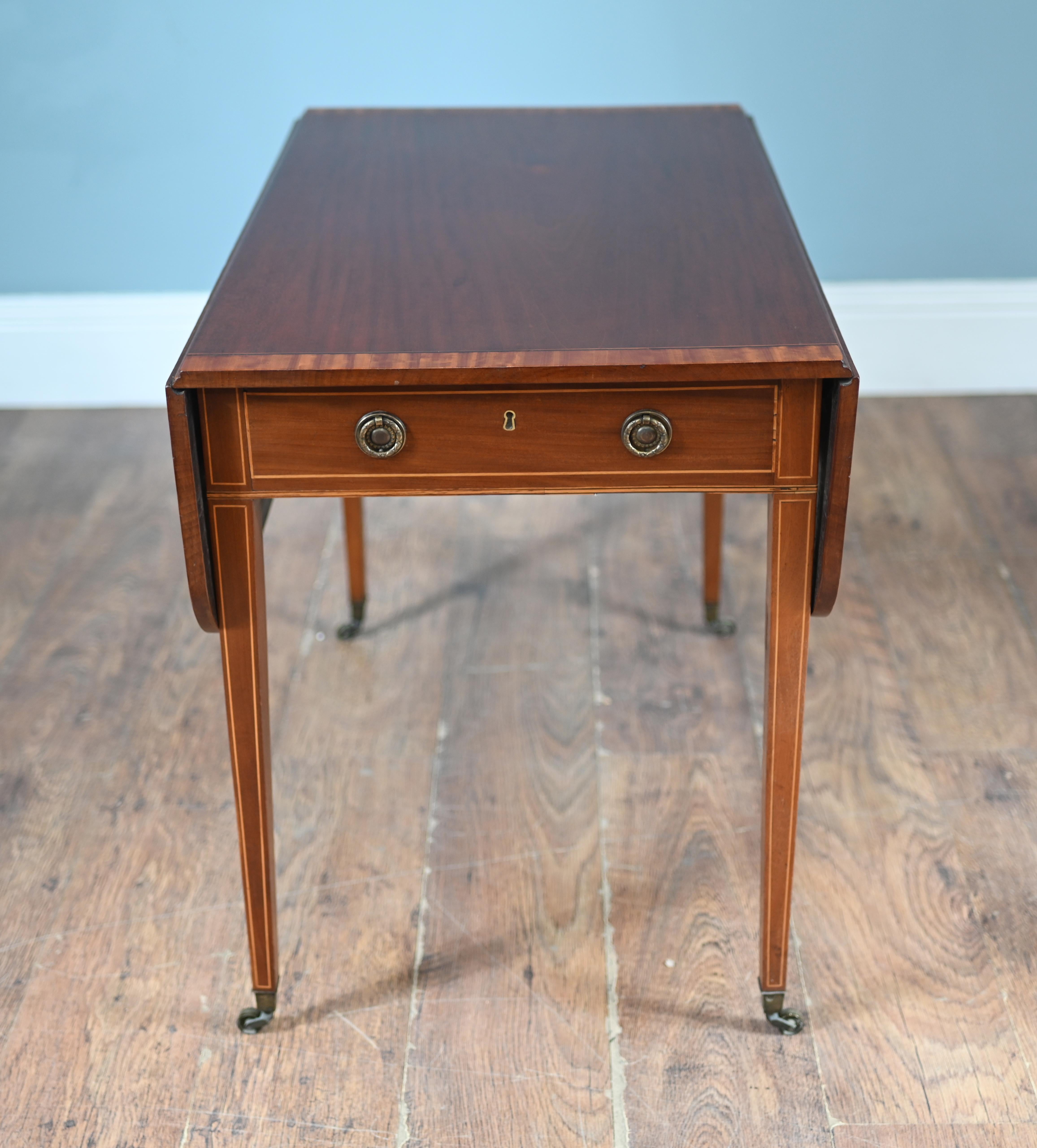 Antico tavolo Pembroke in mogano di epoca Regency con maniglie ad anello e piedini in ottone fuso
L'intero piano è bordato in legno di raso con intarsi a corda intorno ai cassetti e alle gambe.
Circa 1820
Il termine 