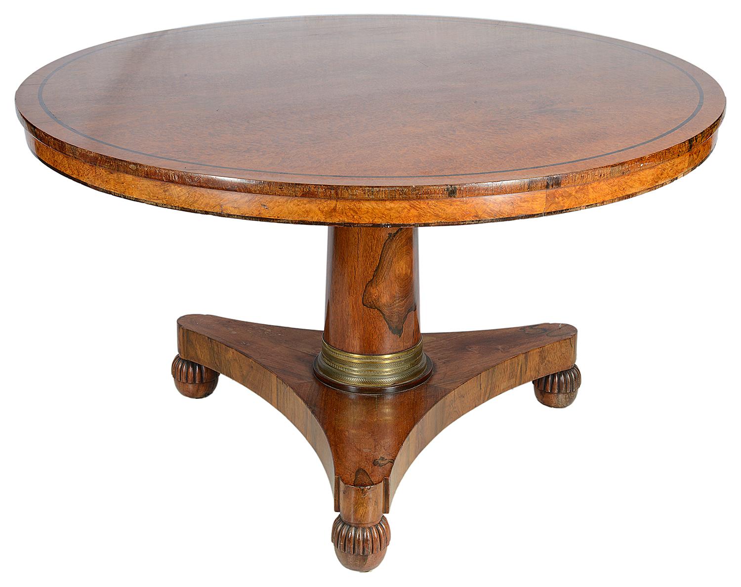 A very good quality 19th century, Regency period Amboyna veneer center table, having a central barrell column with an ormolu collar and raised on carved melon feet.