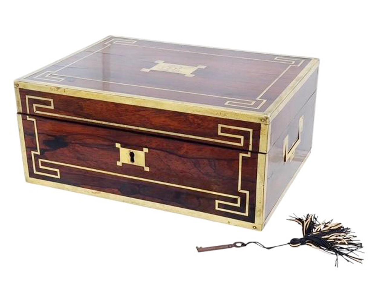 Brass bound Regency period rosewood document box by Wells & Lambe with brass edges, geometric line inlay and flush mounted skeletal lift handles. The top with a monogramed rectangular plaque with outset corners matching the escutcheon plate on the