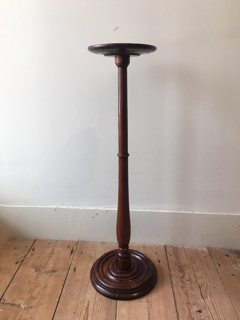 A charming 19th century Regency period solid yew wood candle stand. Small circular lip-edge top on a long elegant turned baluster shaped column. The circular turned base is weighted down with a lead in-set. English, circa 1805.