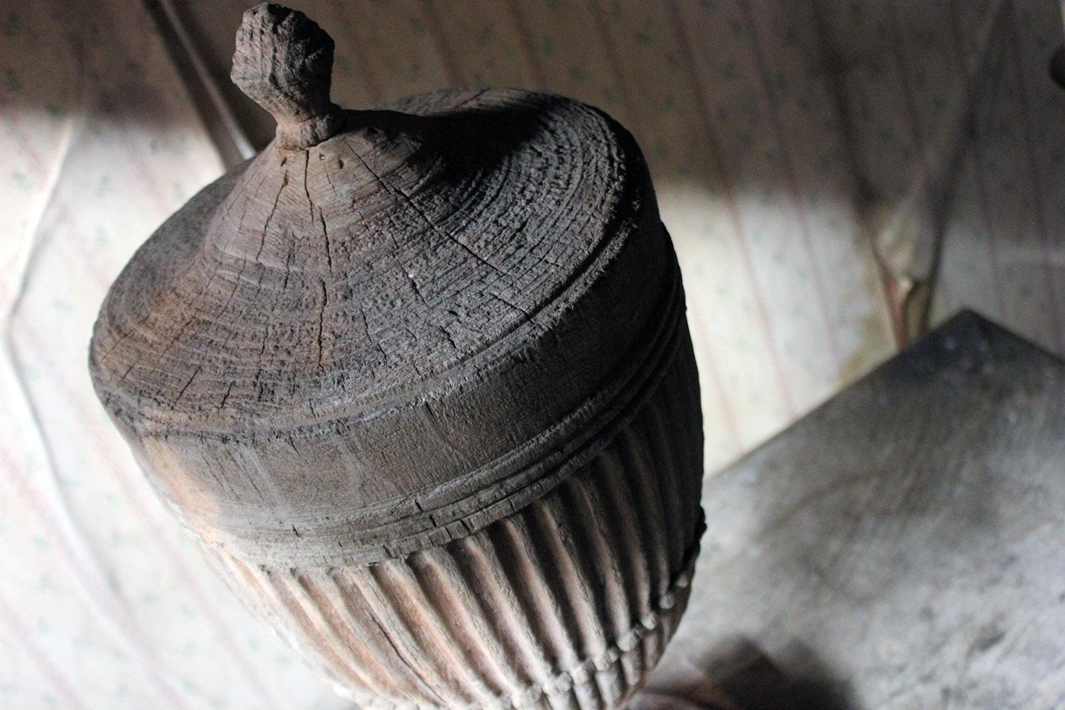 The generously sized unusual early 19th century stripped pine carving in the form of a neoclassical urn, classically shaped, having a conical body, gadrooned and fluted, tapering to circular socle bases on a (later?) square plinth, the whole