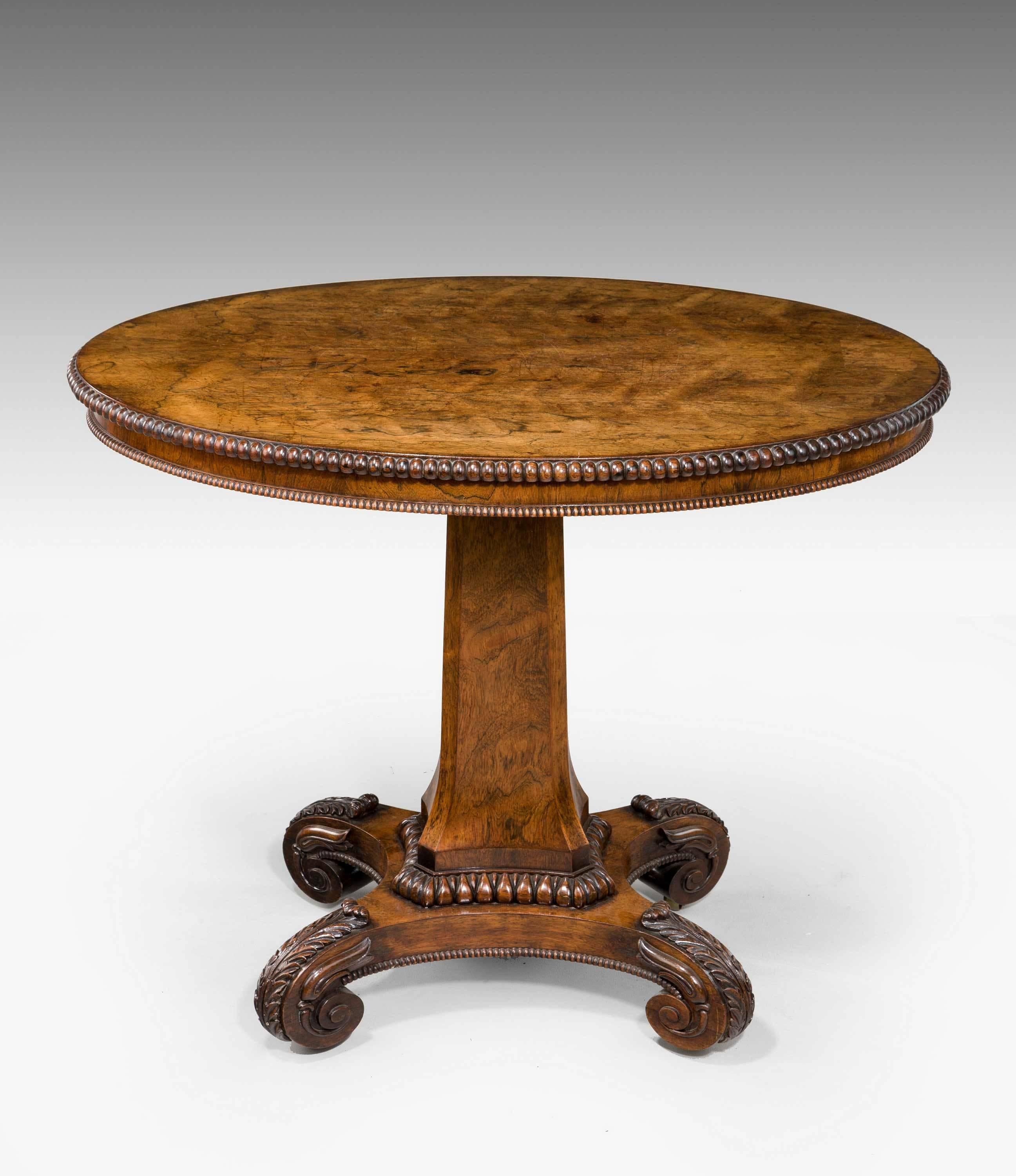Regency period highly figured mahogany centre table of small proportions, the top with its original polished surface, the edge with semi elliptical detailing and matched on the tri form base.
    