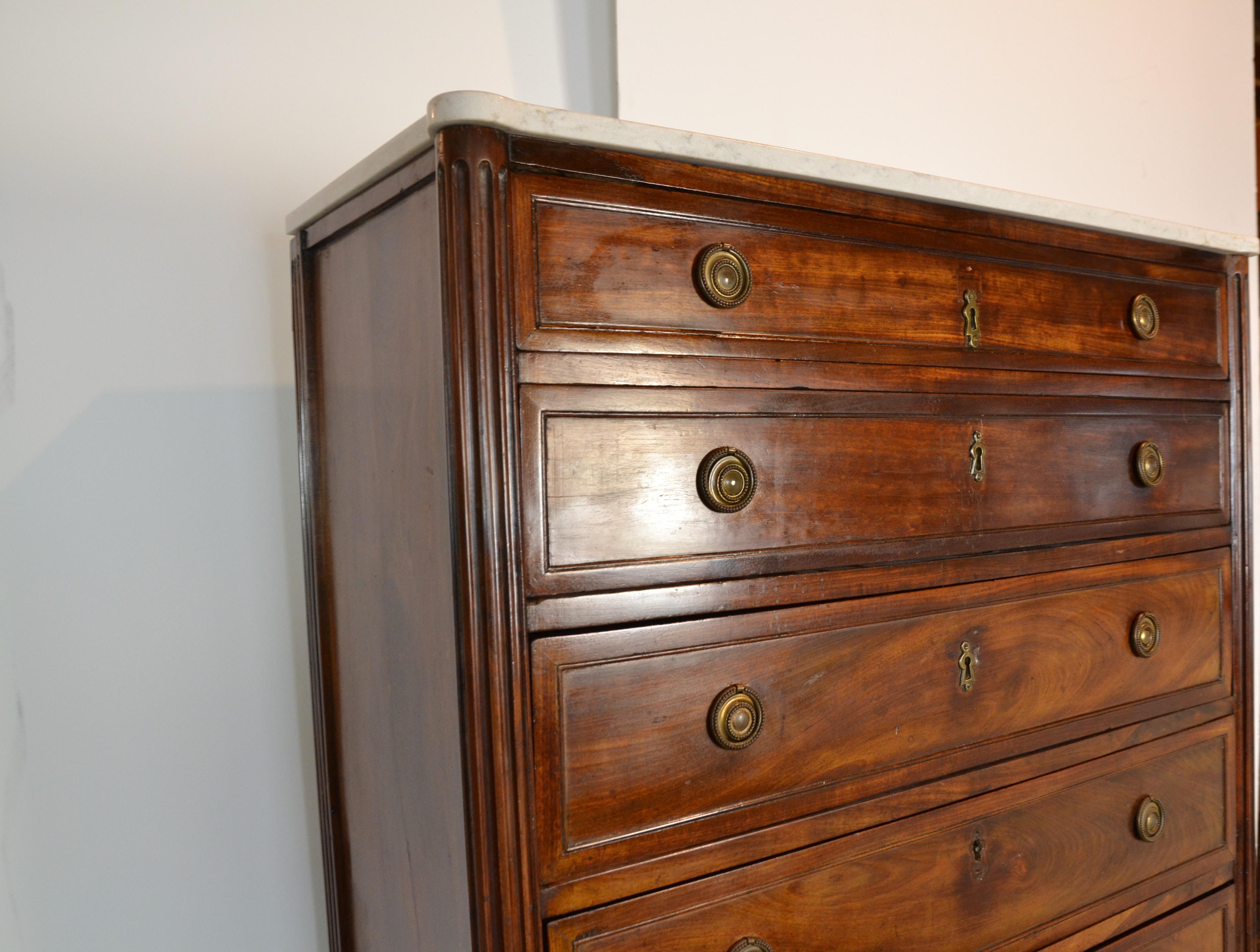 This is a Regency period chest of 8 full length drawers circa 1820. Old grain mahogany with oak and pine lined drawers. Replacement Spanish marble top, cut to original shape. Brass hardware and toe-caps.