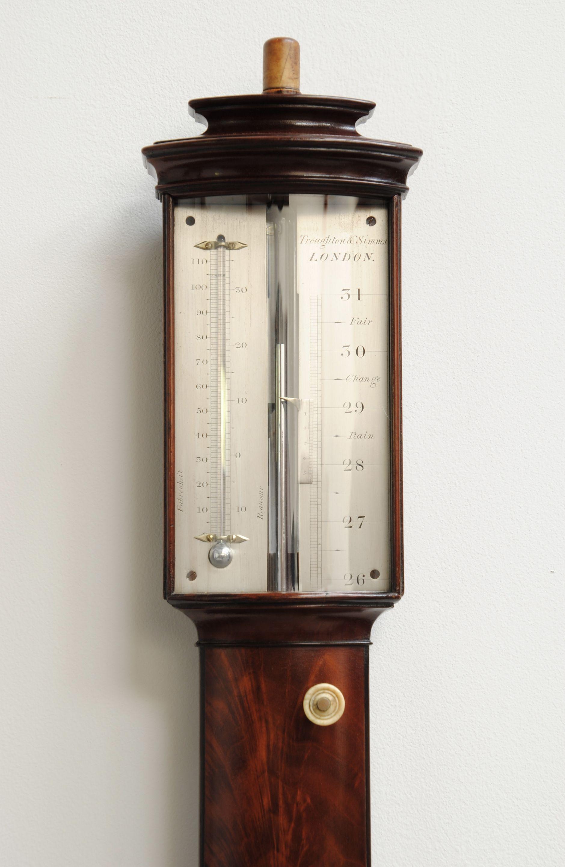 A stunning mahogany bow fronted stick barometer with flame veneers to the case, the silvered dial signed Troughton and Simms, London. The top of the case with a box wood finial flowing you to put today’s pressure on a caed in the slot. The case