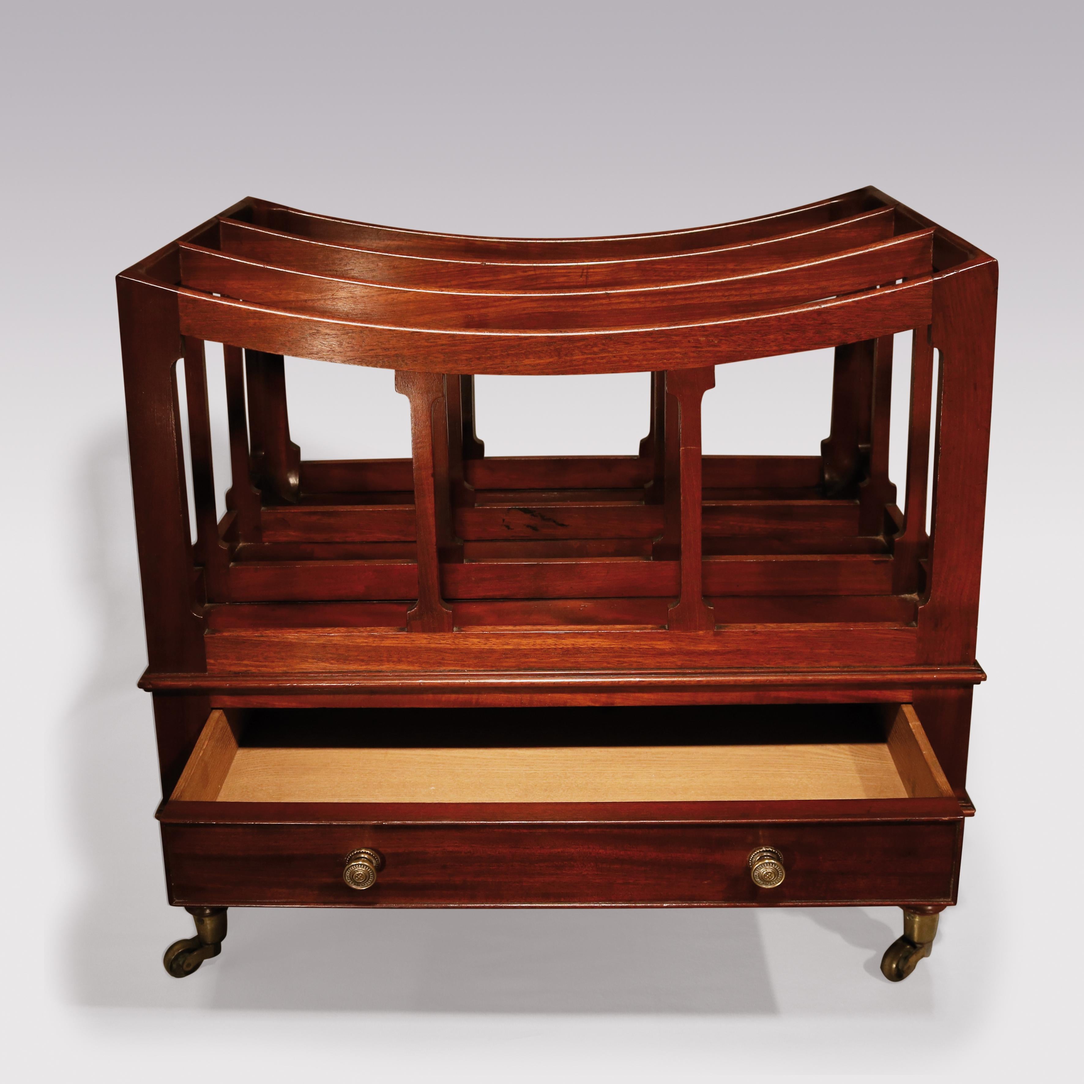 An early 19th century Regency period mahogany 3-section Canterbury, having curved sections with silhouette column supports, fitted with frieze drawer, supported on baluster turned legs, ending on original brass castors.