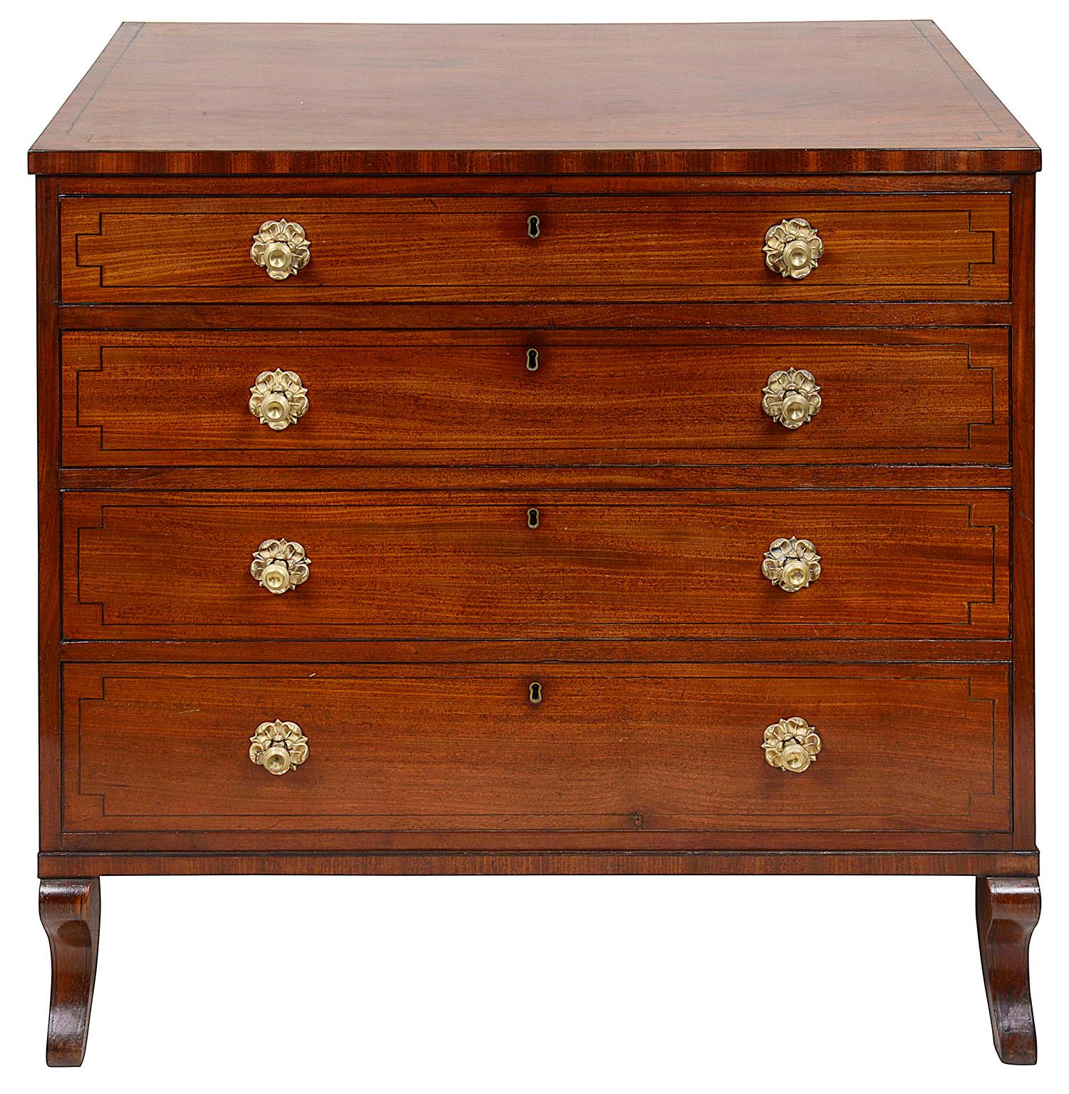 A very good quality early 19th century Regency period mahogany chest of drawers, having a crossbanded top, ebony string inlay to the fronts of the four graduating drawers, each having their original flower pedal like handles, and raised on four out