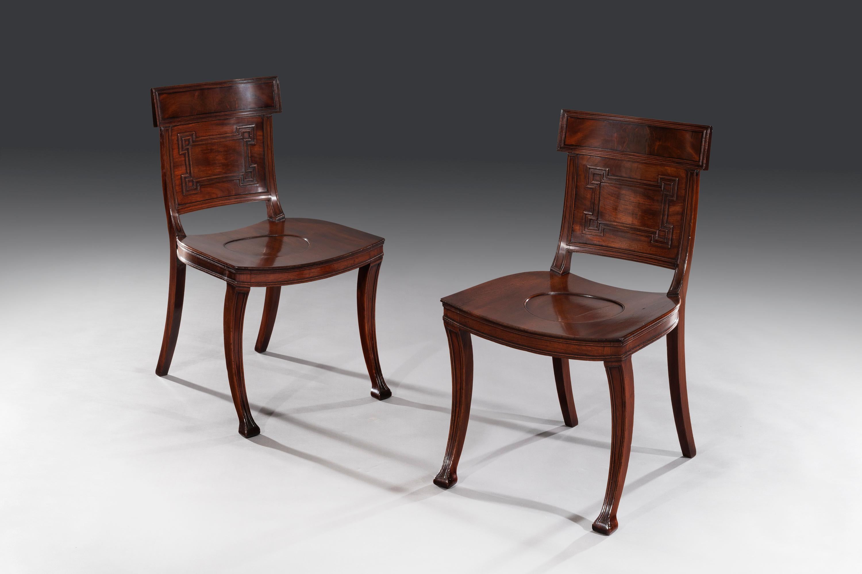 The mahogany veneered back splats sit above 'Greek Key' moulded backs and are flanked by reeded uprights. The saddle-shaped seat stands on sabre front legs and down-swept back legs, 

Elward, Marsh and Tatham, see C. Gilbert, Pictorial Dictionary