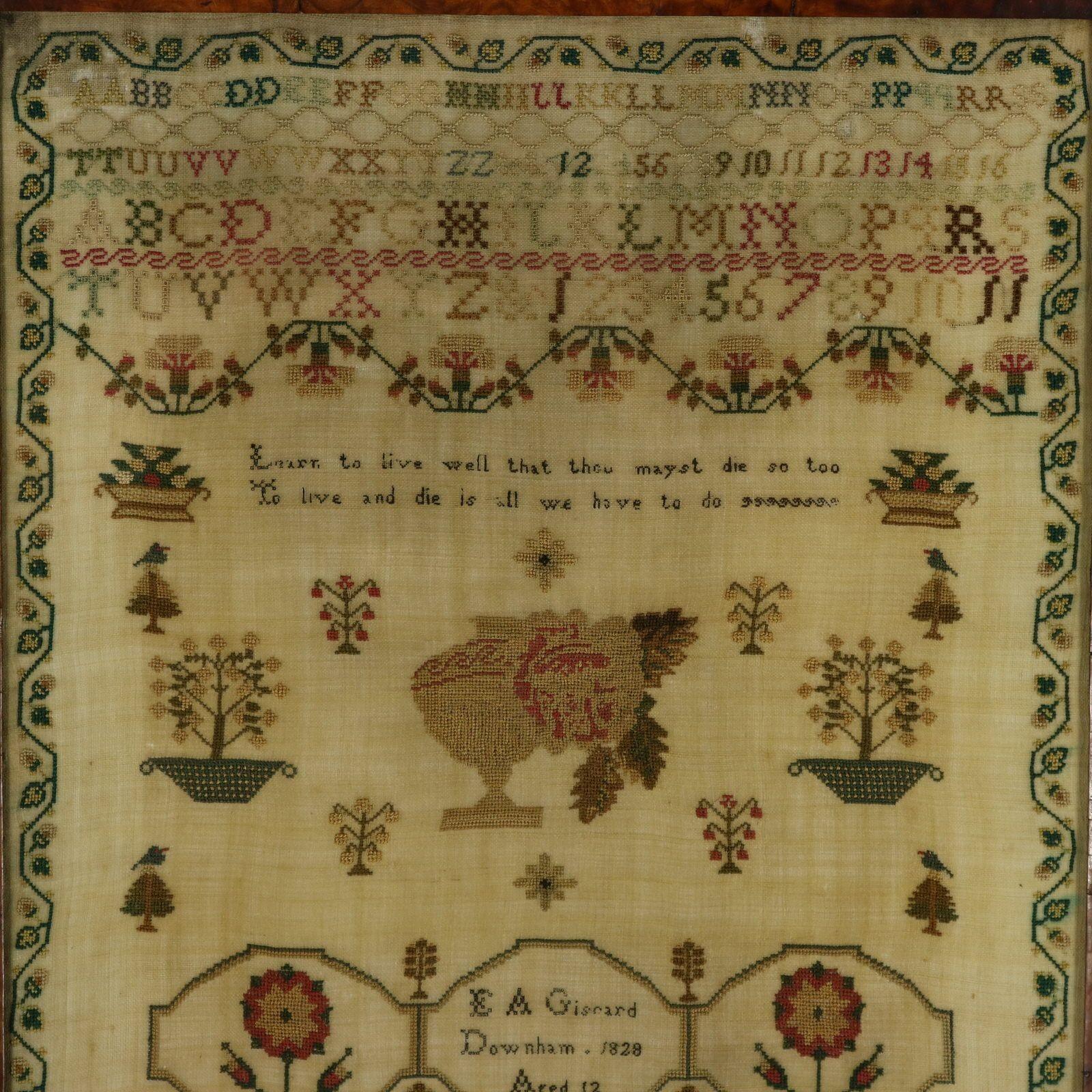 Norfolk Sampler d'époque Régence, 1828, par E A Giscard Agé de 12 ans. Le sampler est réalisé en fils de soie sur fond de lin, au point de croix et à l'œil algérien. Bordure sinueuse de fraises et de feuilles. Couleurs : vert, rouge, brun clair,
