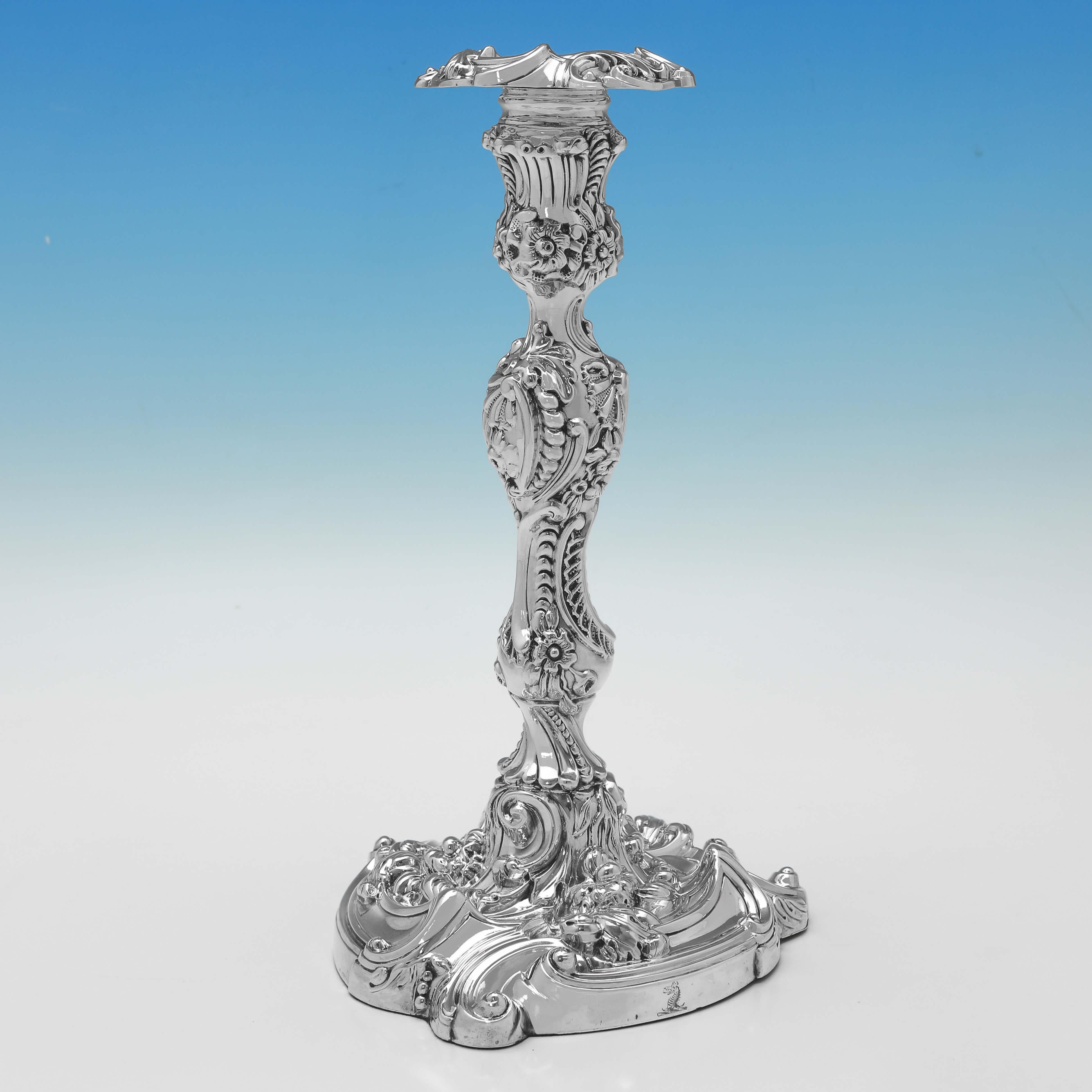 Hallmarked in Sheffield in 1816 by Kirkby Waterhouse & Co., this striking pair of Regency Period, Antique Sterling Silver Candlesticks, are richly decorated and have removable nozzles and engraved crests. 

Each candlestick measures 10.5