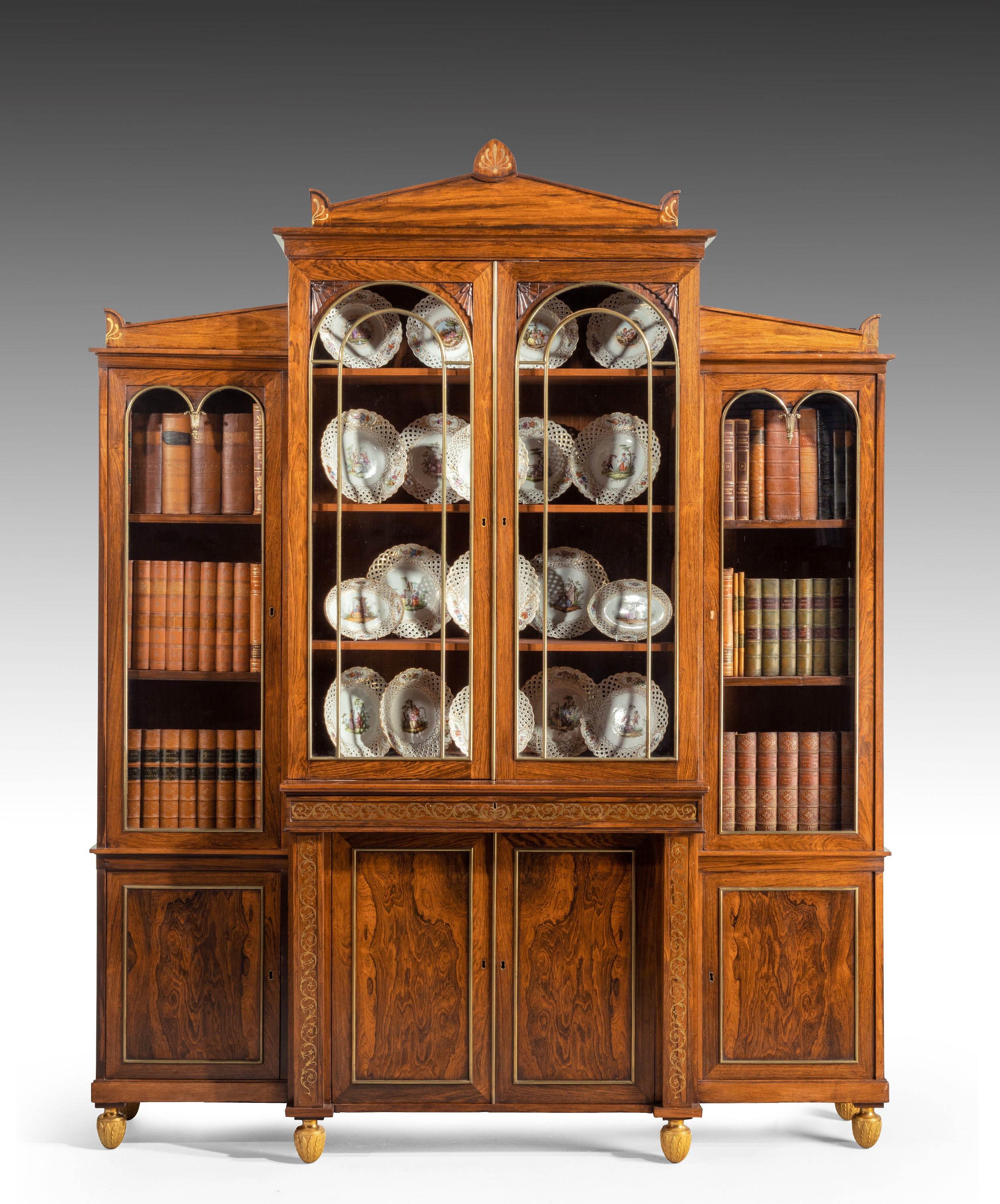 An exceptionally elegant and fine quality Regency period rosewood bookcase / China cabinet of breakfront form. The waist and upright to the bases beautifully inlaid scrolled brass work. The top with anthemion details to the corners and giltwood and