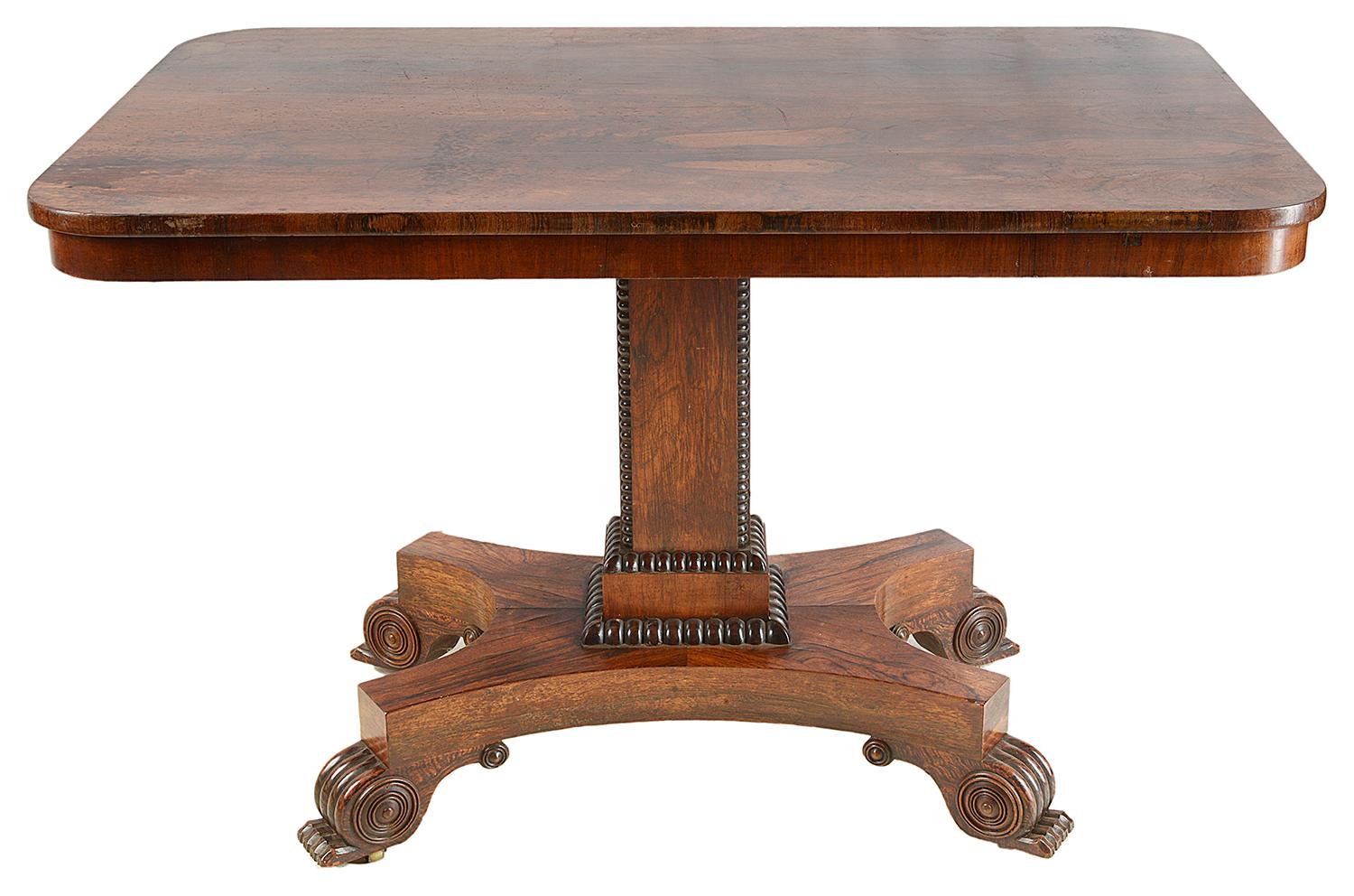 A good quality Regency period breakfast table, raised on a square section pedestal, platform base with carved scrolling feet.