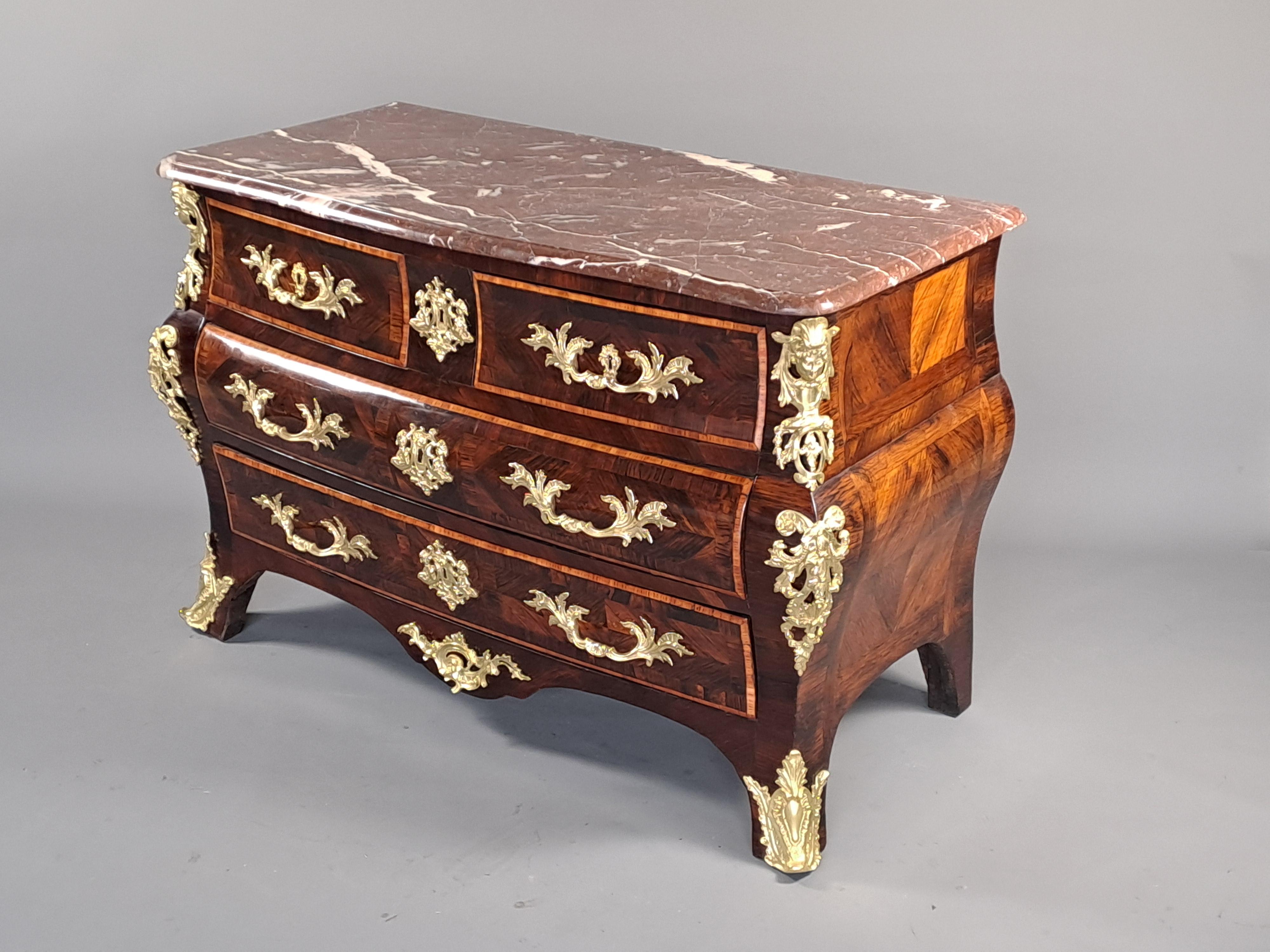 Beautiful tomb chest of drawers with generous shapes made of geometric rosewood marquetry.  Drawers framed with rosewood fillets.  Rich gilded and chiseled bronze ornamentation.  Opening four drawers in three rows.  Royal Belgian marble top with bec