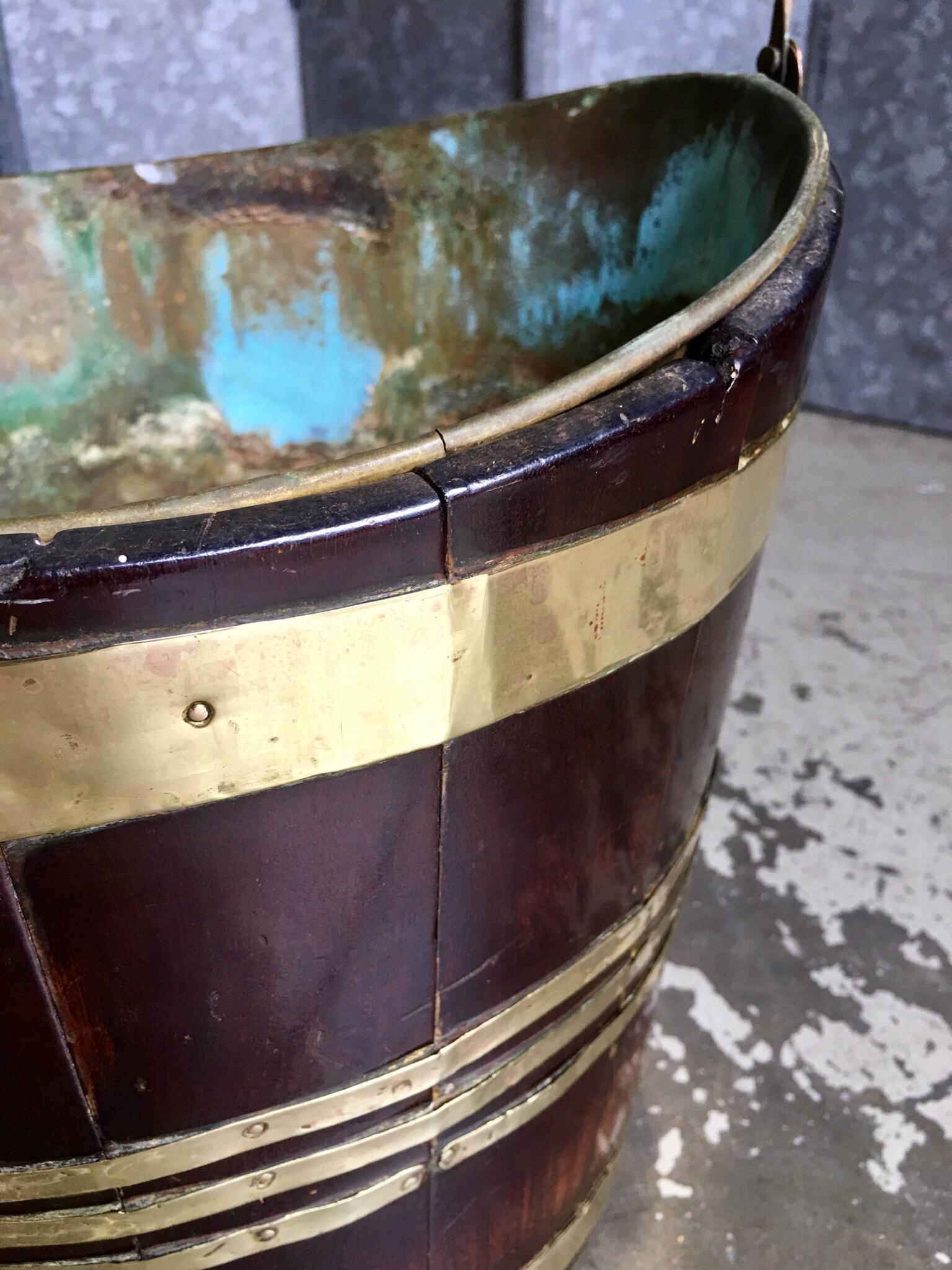 George II period mahogany coopered peat bucket with original brass insert with verdigris patina. Minimal restoration in original condition. The brass insert has wonderful verdigris patination.